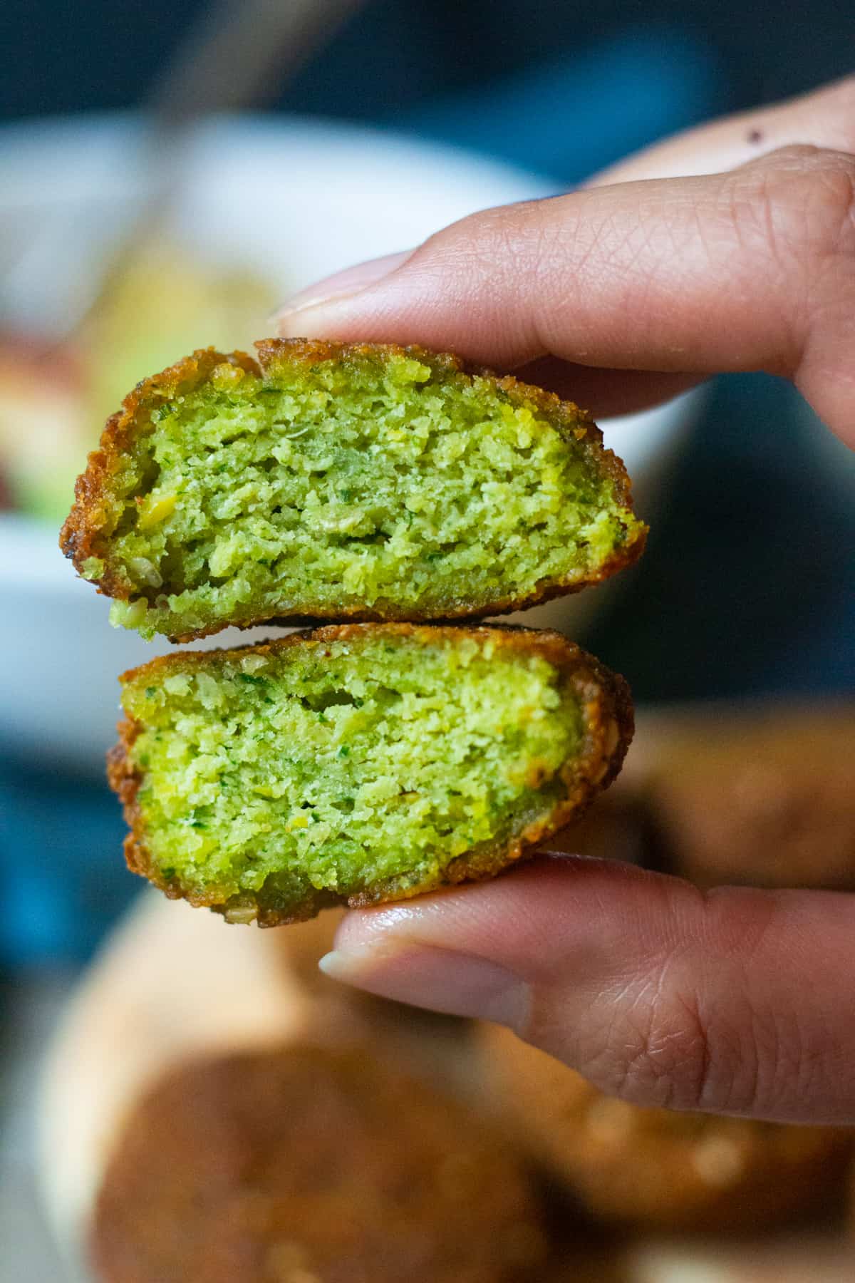 falafel cut in half and inside is green because of herbs .