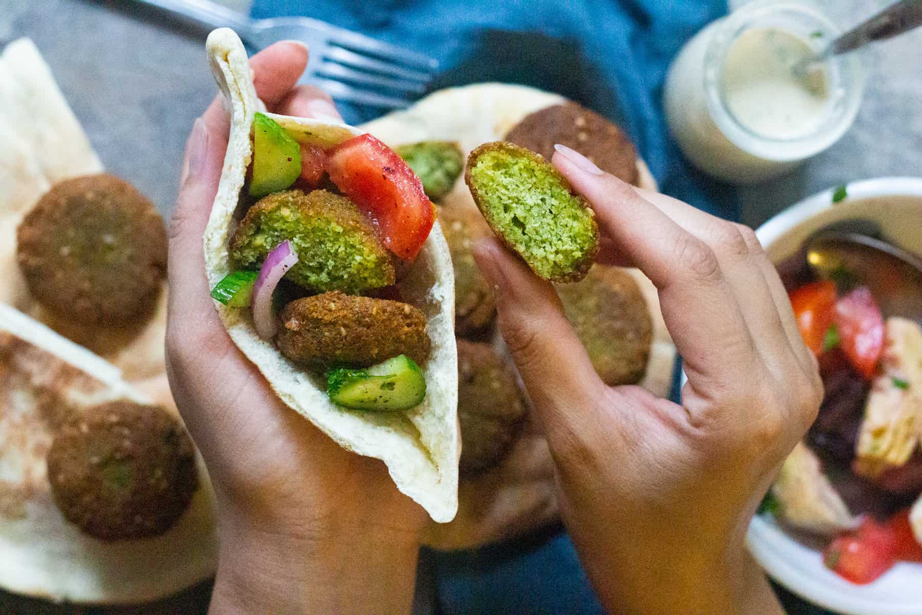 Stuff pita bread with falafel, vegetables, and tahini sauce. 