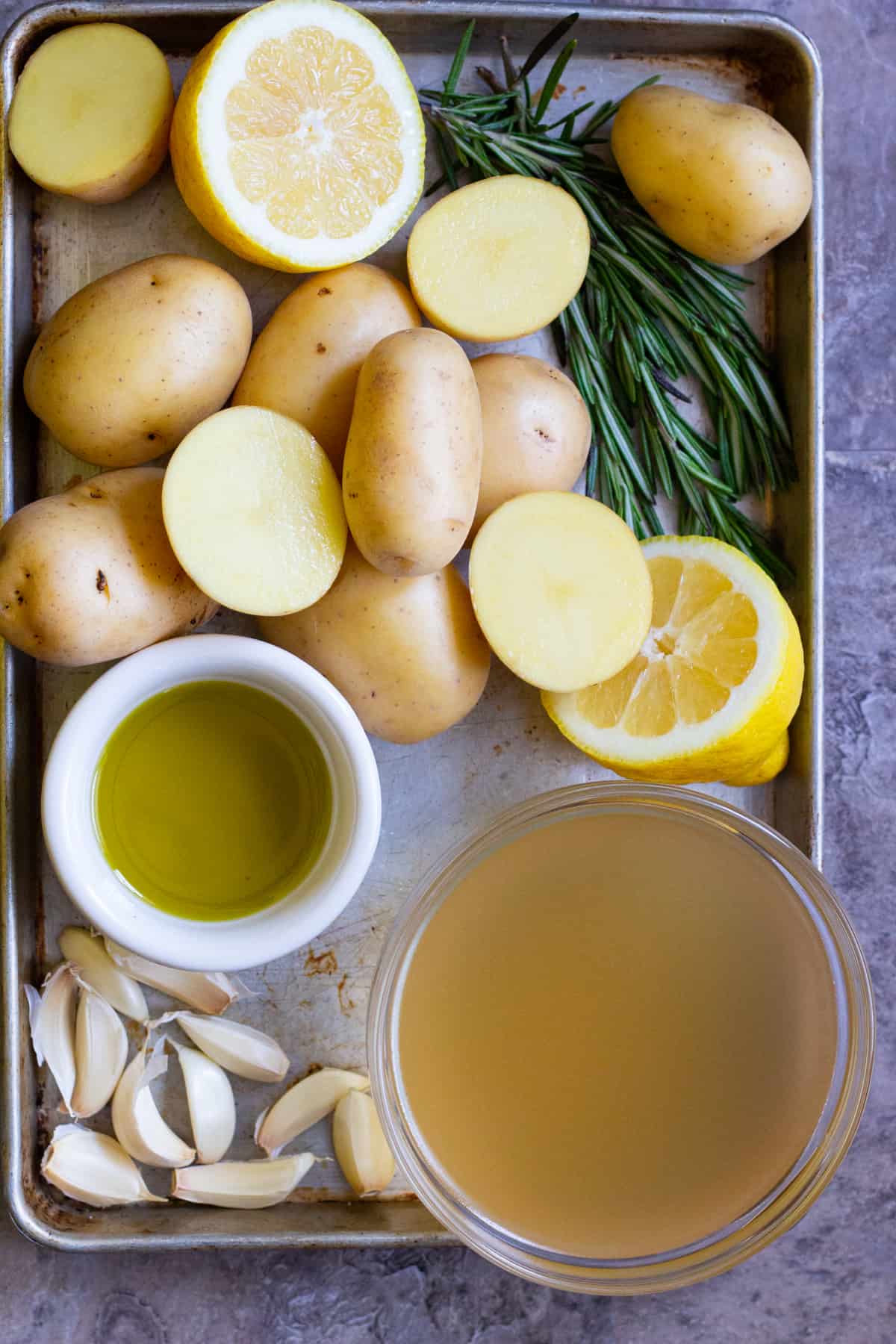 Greek potatoes recipe calls for potatoes, lemon, rosemary, olive oil, chicken broth and garlic