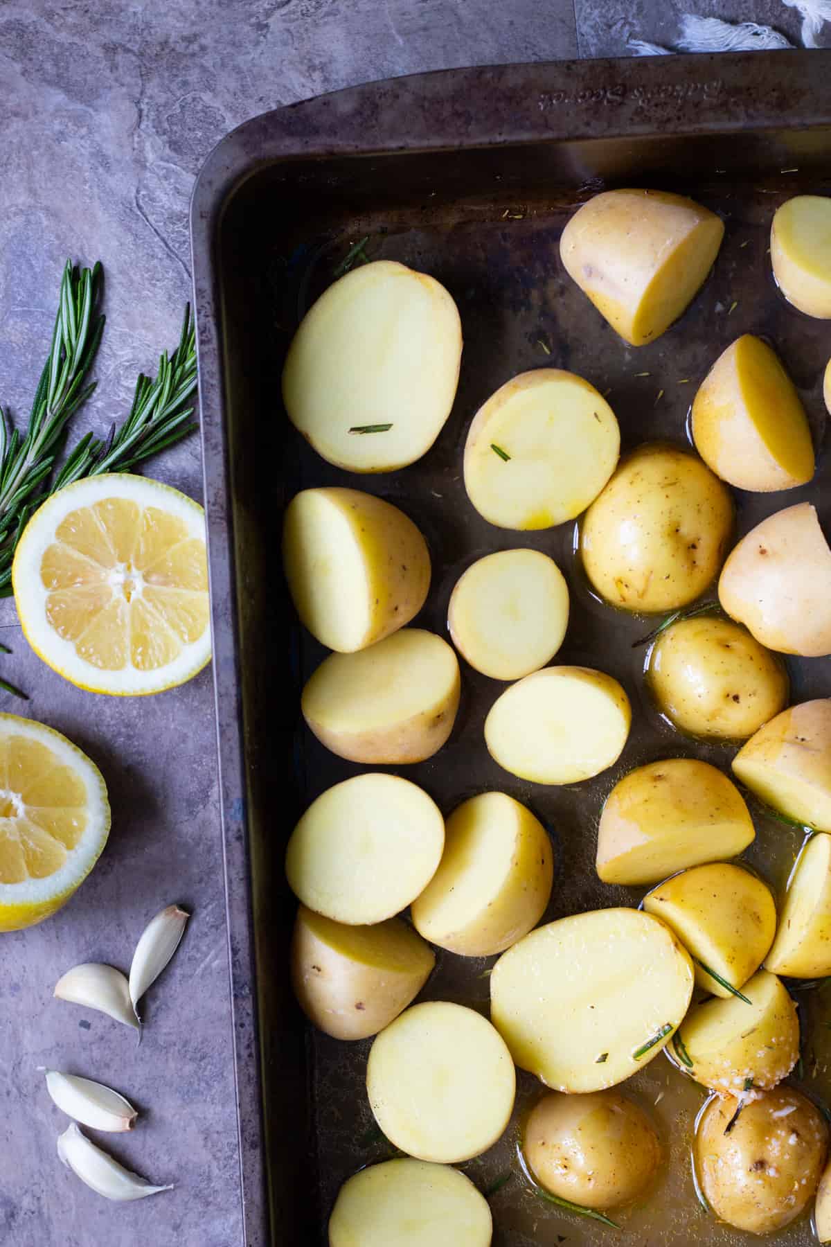 To make Greek roasted potatoes mix all the ingredients together and place them in a deep baking pan and bake in the oven.