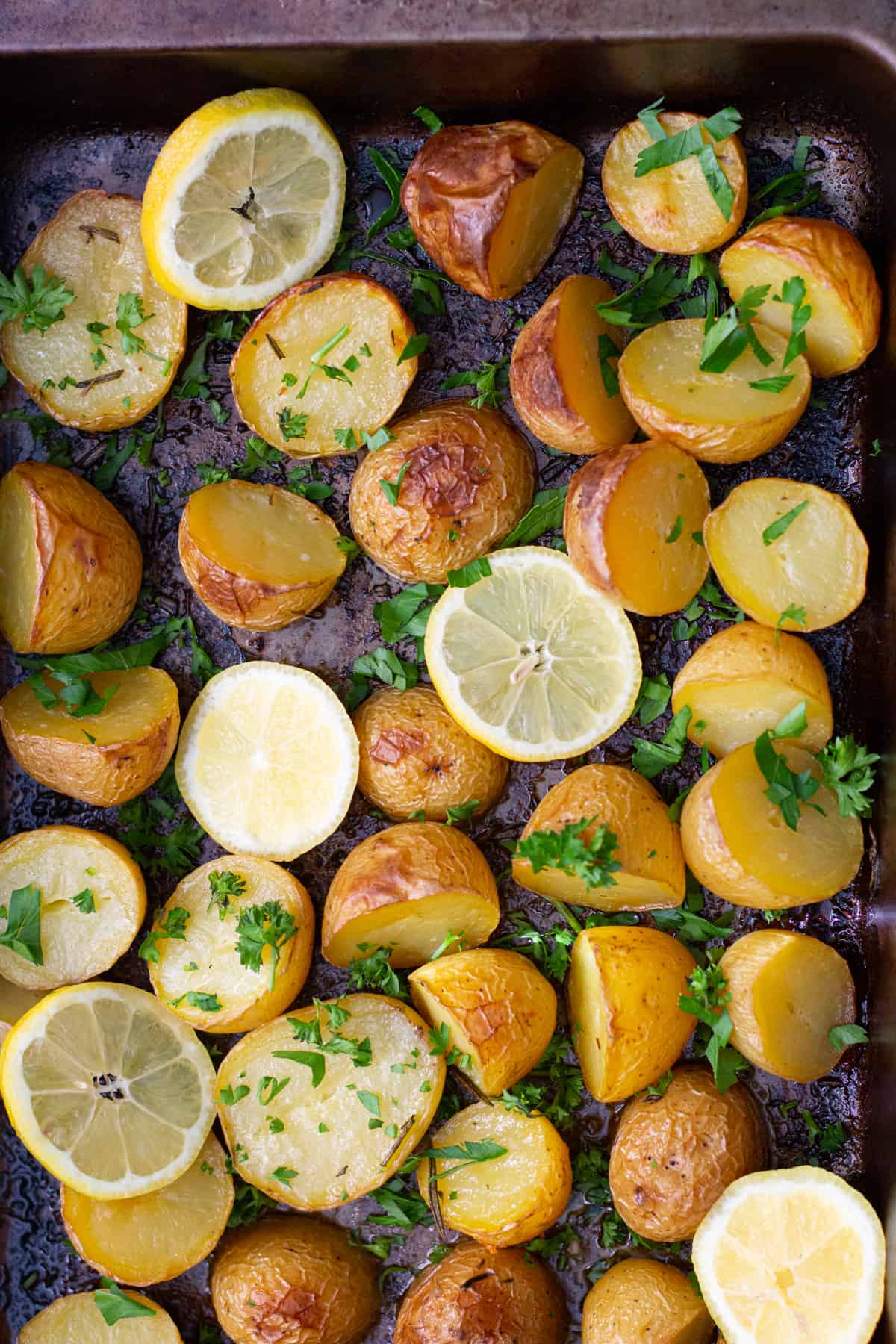 Greek style potatoes are roasted in the oven and served with lemons