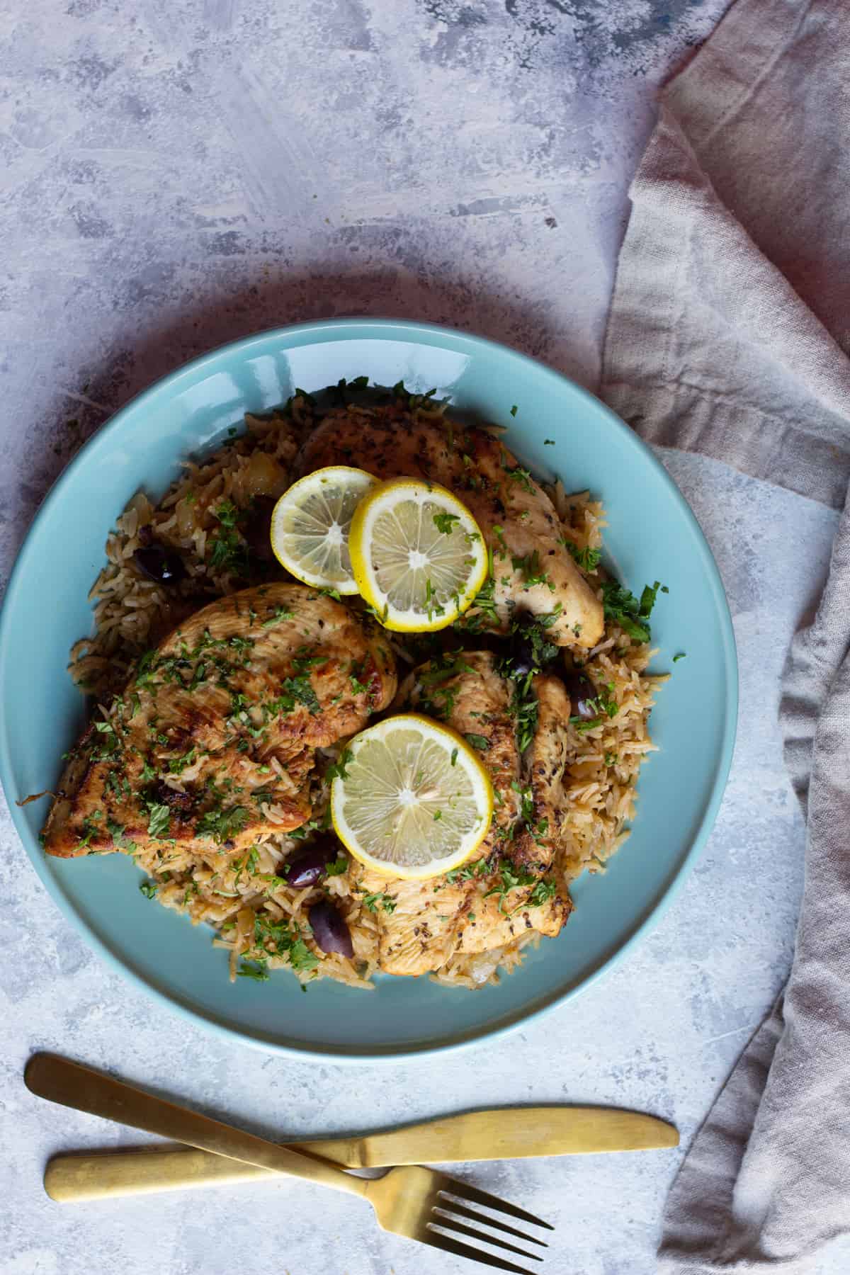 A plate of rice and chicken with utensils 