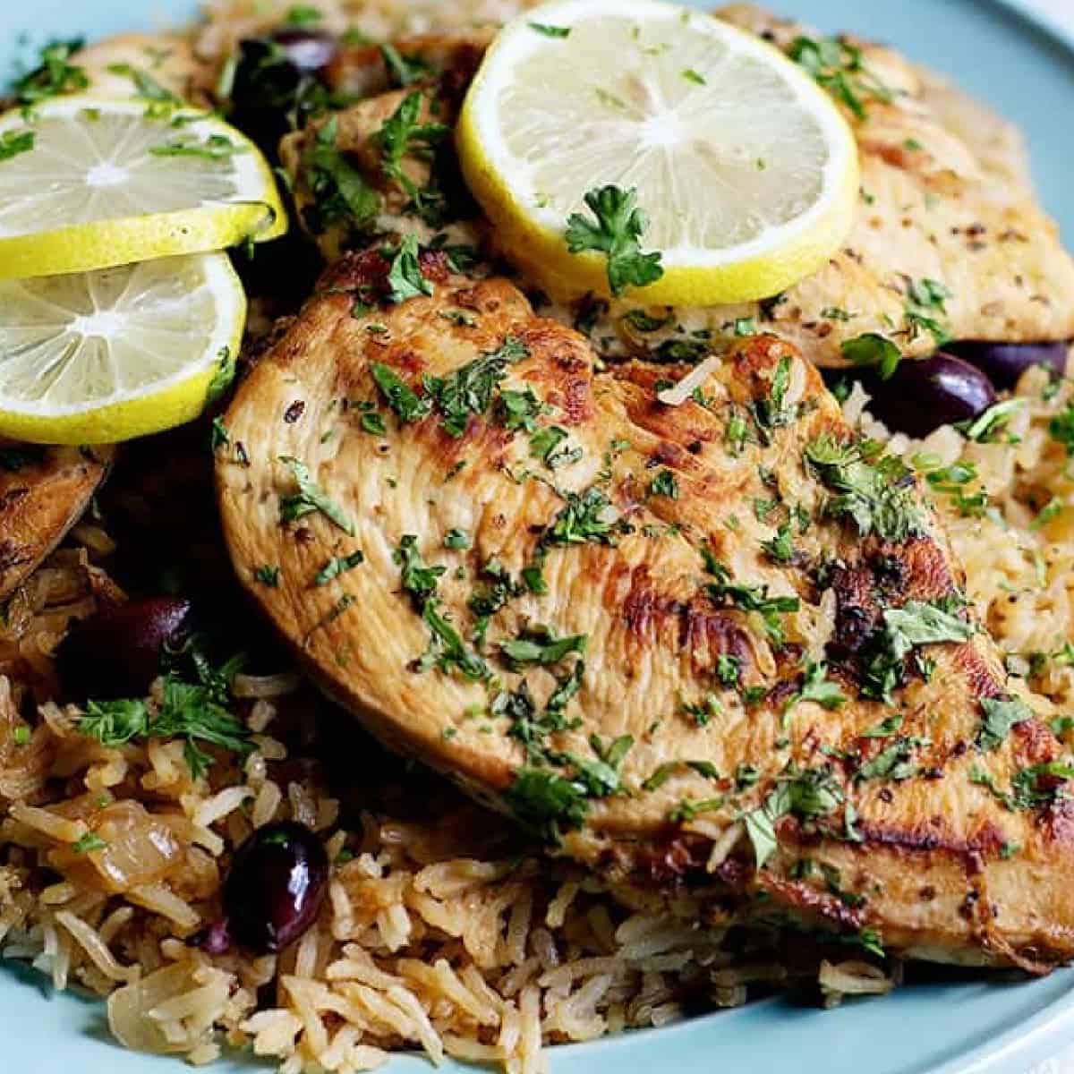 cooked chicken breast on rice with olives and lemon. 