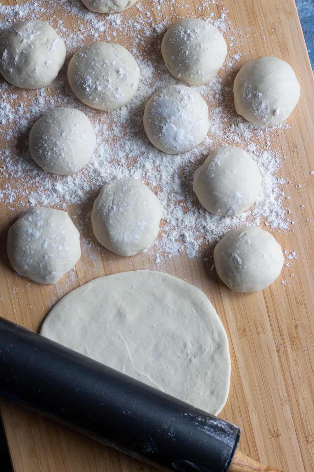 Divide Lahmacun dough into 12 balls and roll our very thin.