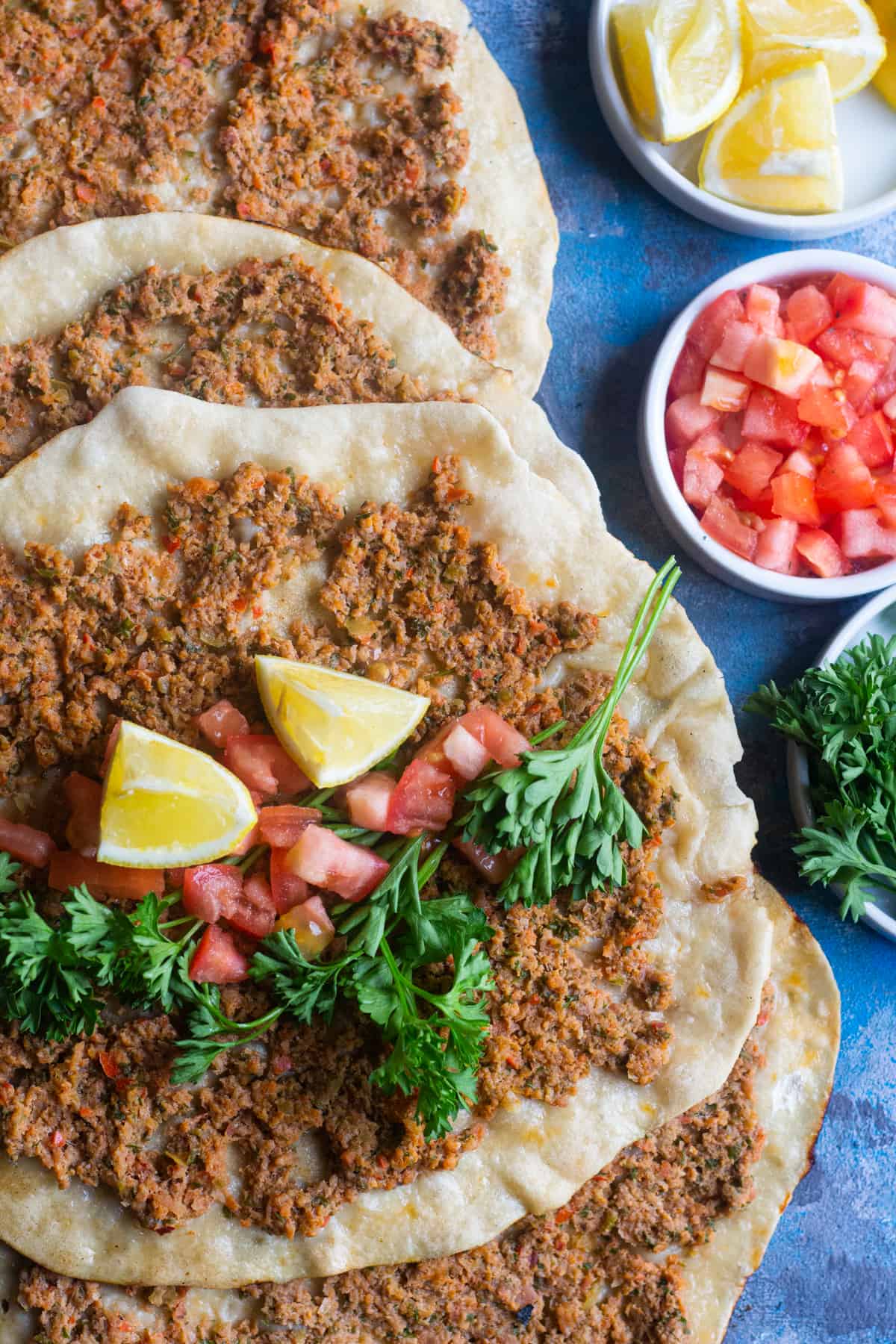 Lahmacun is thin and crispy flatbread bursting with flavor. Topped with meat, parsley, peppers, tomatoes and a mixture of delicious spices, this Turkish pizza is a must-try! 
