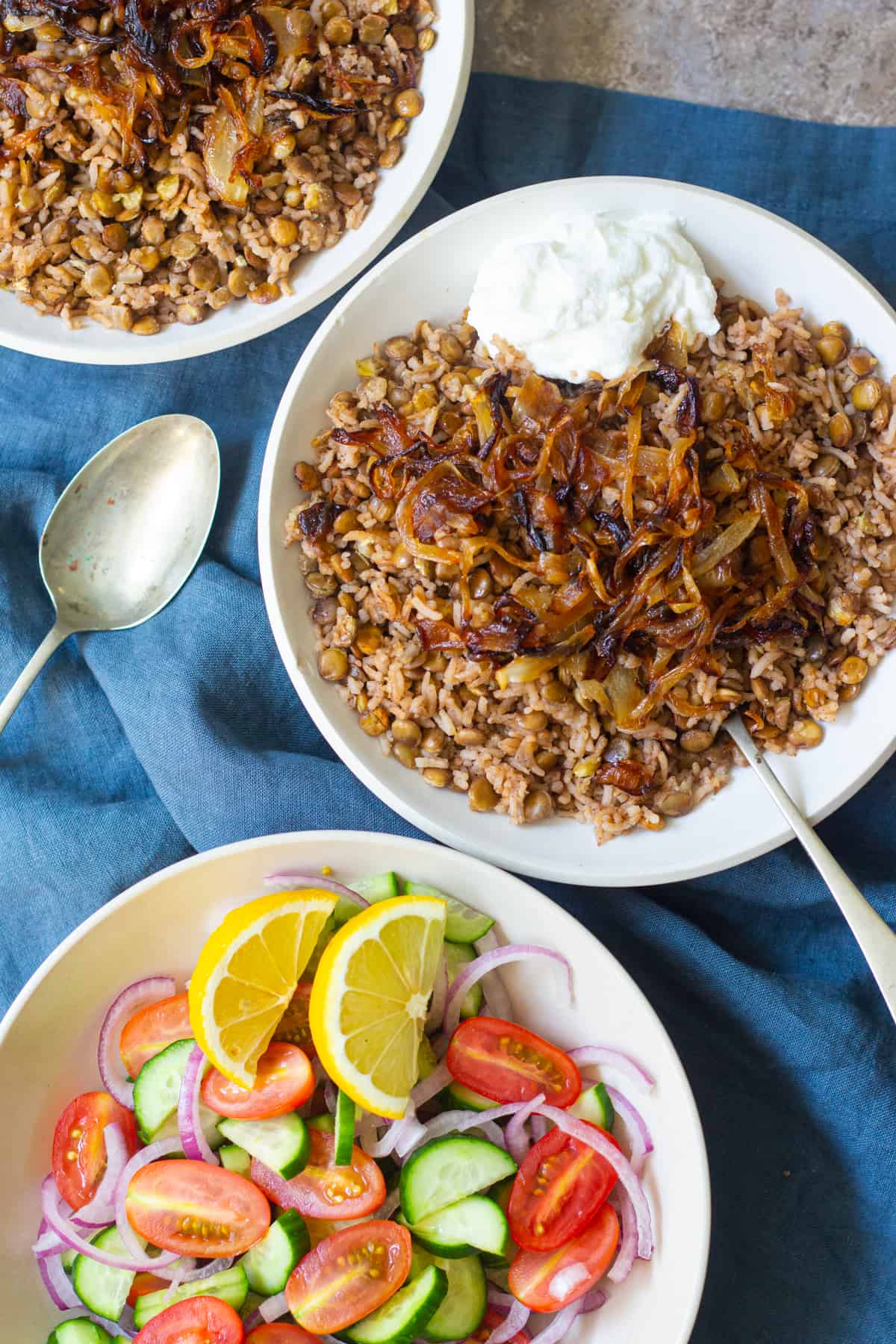 two bowls of lentil rice and onions on a blue napkin. 