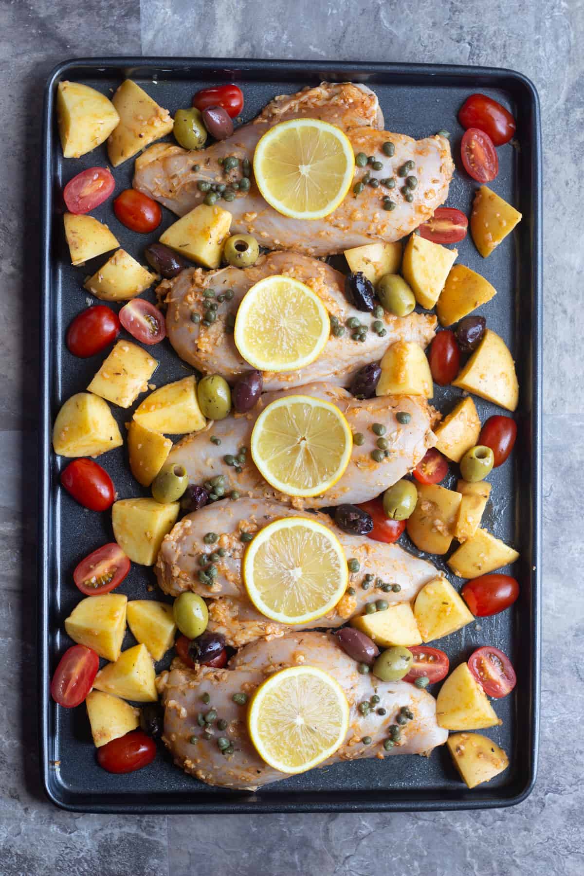 Mediterranean chicken marinade is made with lemon, olive oil, garlic and spices. Marinade the chicken and place it with the vegetables on a baking sheet. 