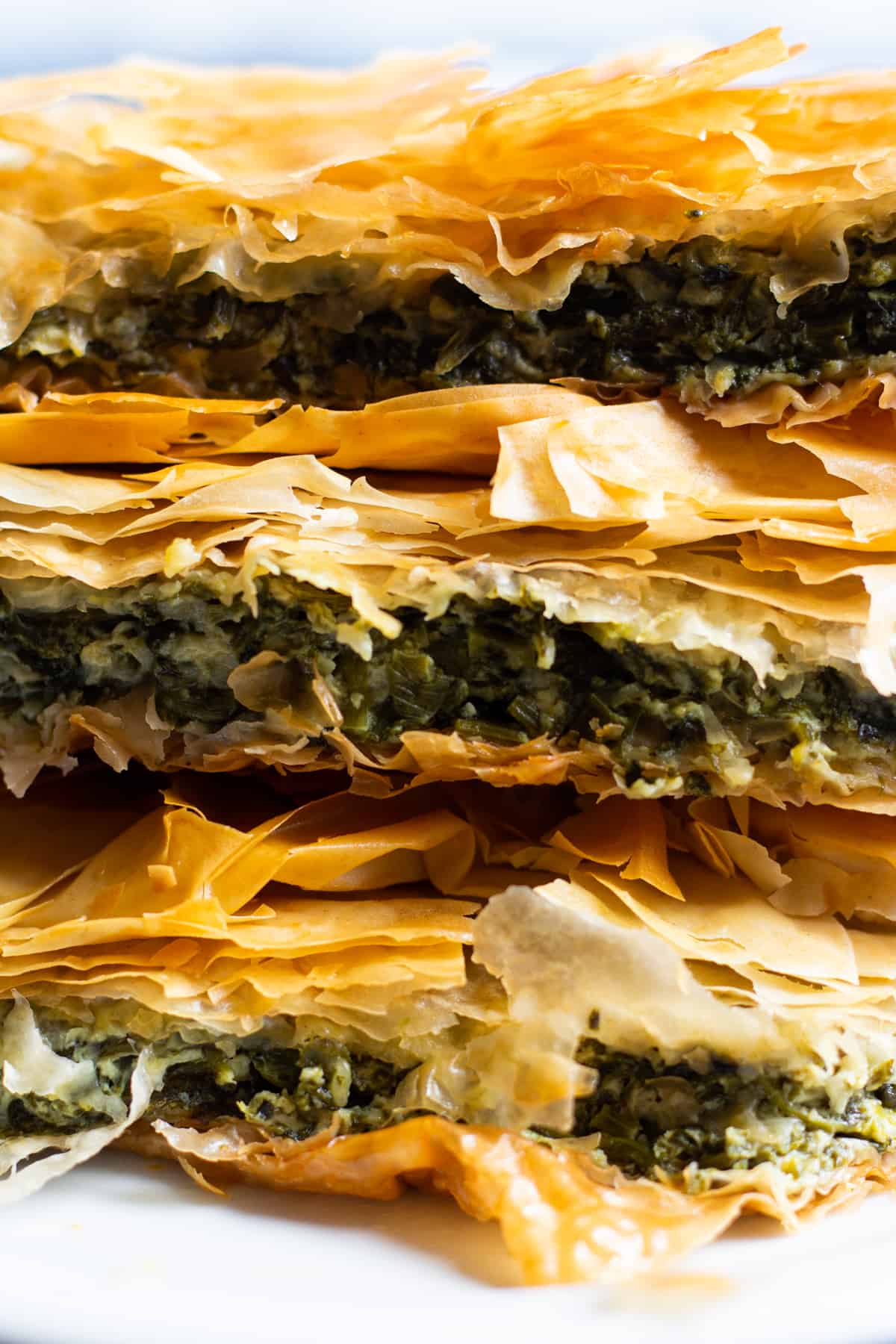 Spanakopita is a classic Greek pie made with phyllo dough, spinach and feta. It's packed with so much flavor and one slice is never enough! Learn how to make spanakopita recipe with a video tutorial. 
