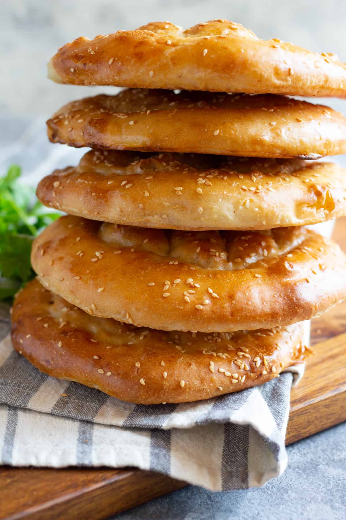 This flatbread is about 1/2 inch thick and is topped with sesame seeds and a yogurt egg yolk glaze.
