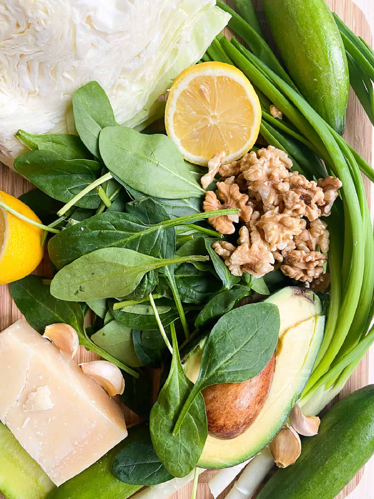 ingredients shot with cabbage spinach lemon avocado green onions walnuts and parmesan.