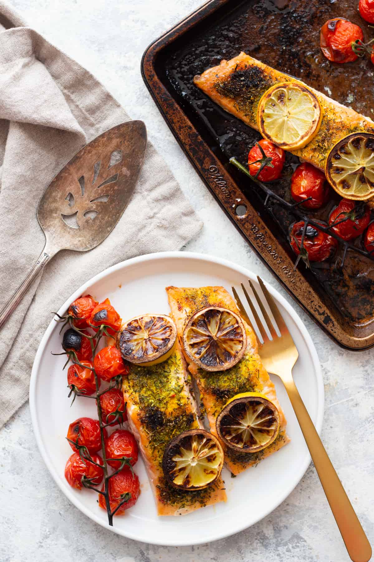 Two pieces of broiled salmon on a plate. 