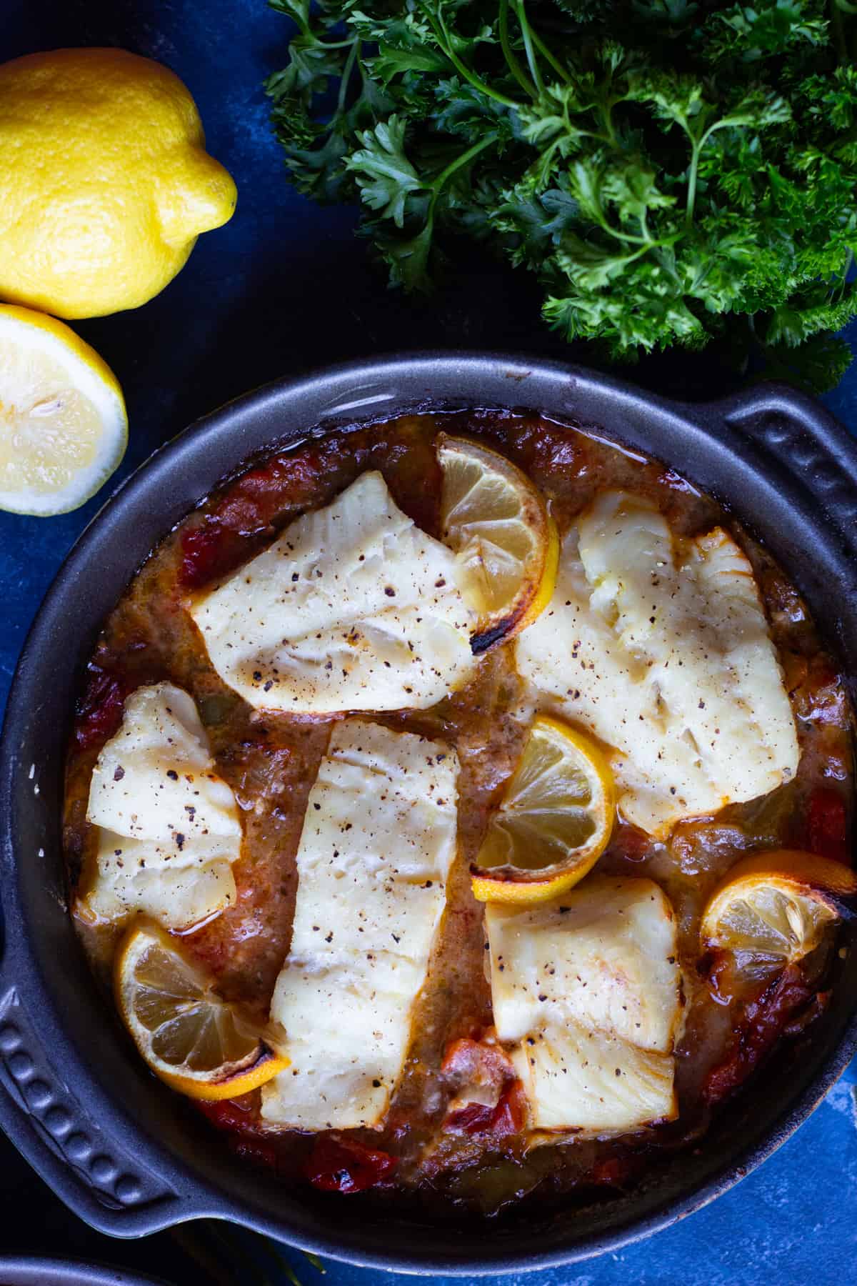 a pan of cooked white fish in a tomato sauce. 