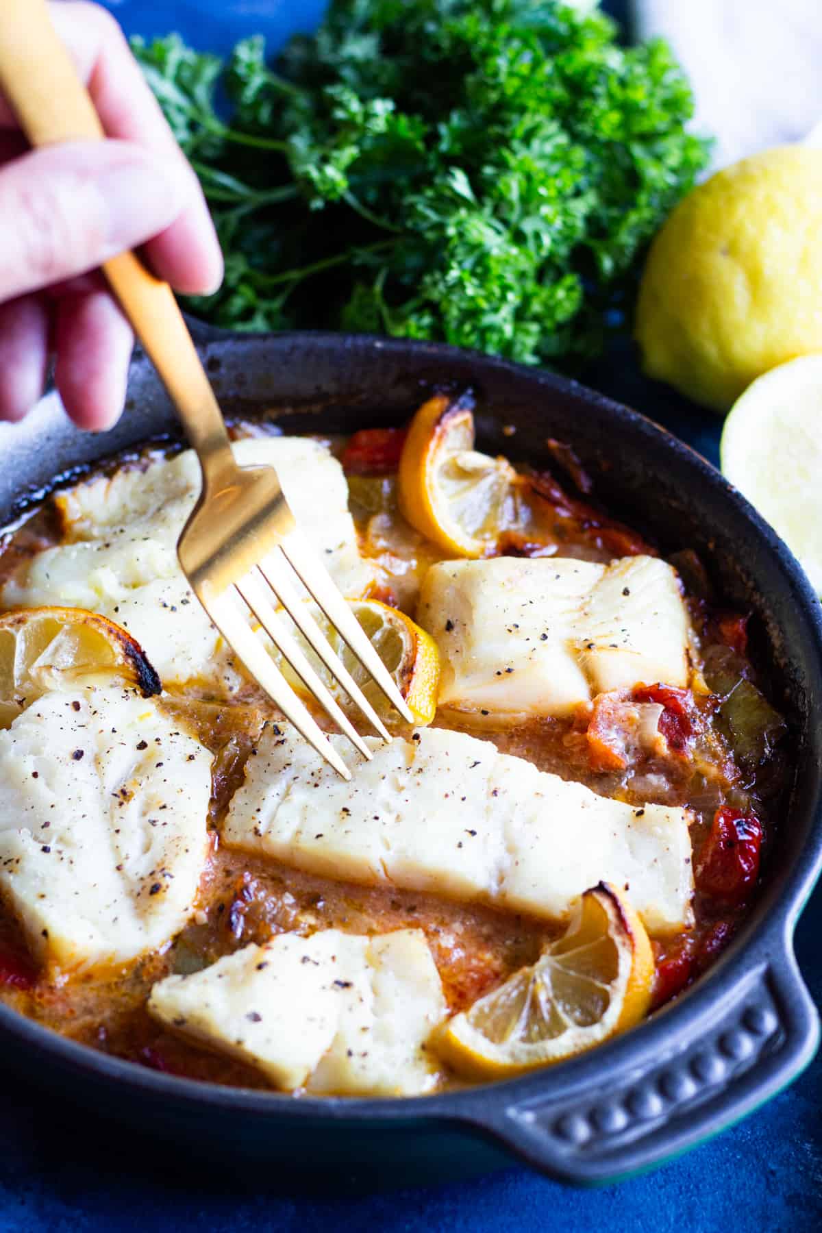Baked cod in a clay pan with tomatoes, onions and peppers.
