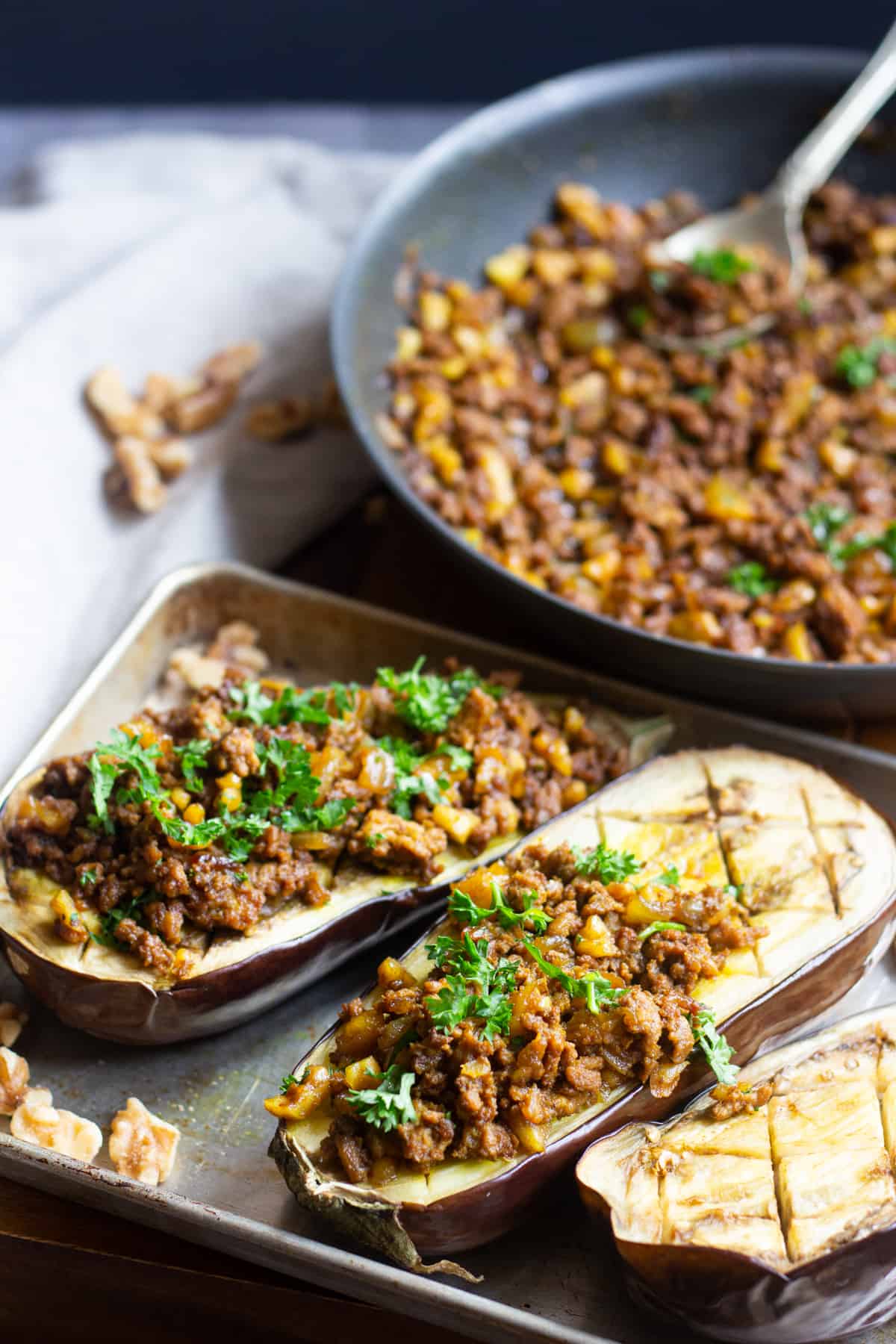 Top eggplants with sauteed lamb and walnuts. Garnish with parsley. 