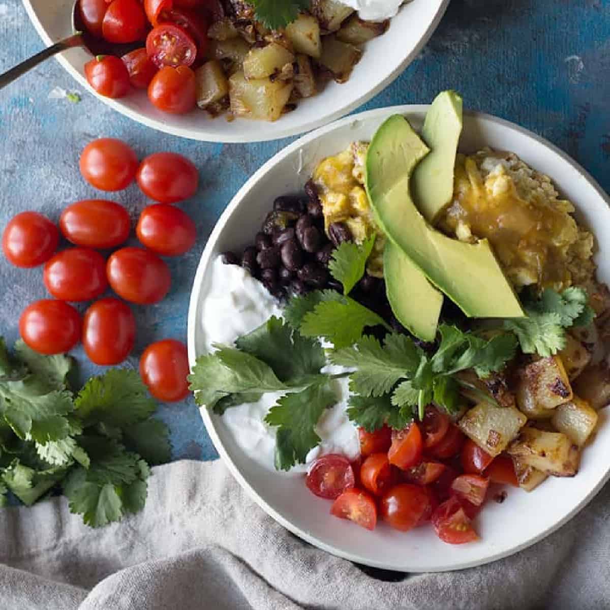 An easy and tasty Mexican-inspired breakfast bowl made with fresh ingredients. Delicious scrambled eggs and home fries make a tasty bowl with fresh avocado and tomatoes. 
