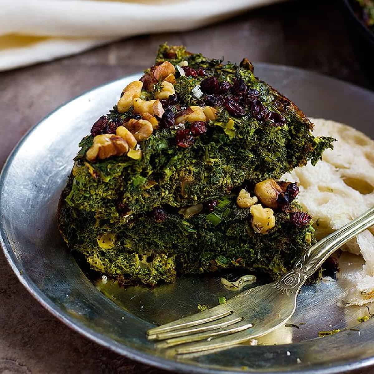 Kuku Sabzi is a Persian Herb Frittata that can be baked in the oven and is topped with barberries and walnuts. It's a great recipe to use up all the herbs!
