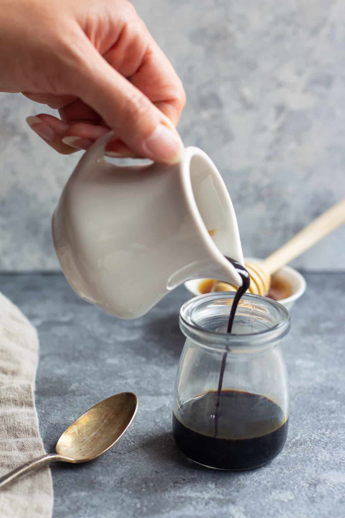 balsamic glaze pouring into a glass jar.