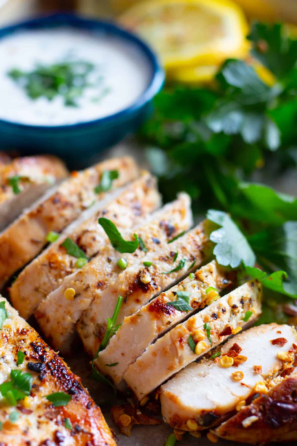 Close-up shot of juicy chicken breast cooked with Greek spices sliced into pieces. 