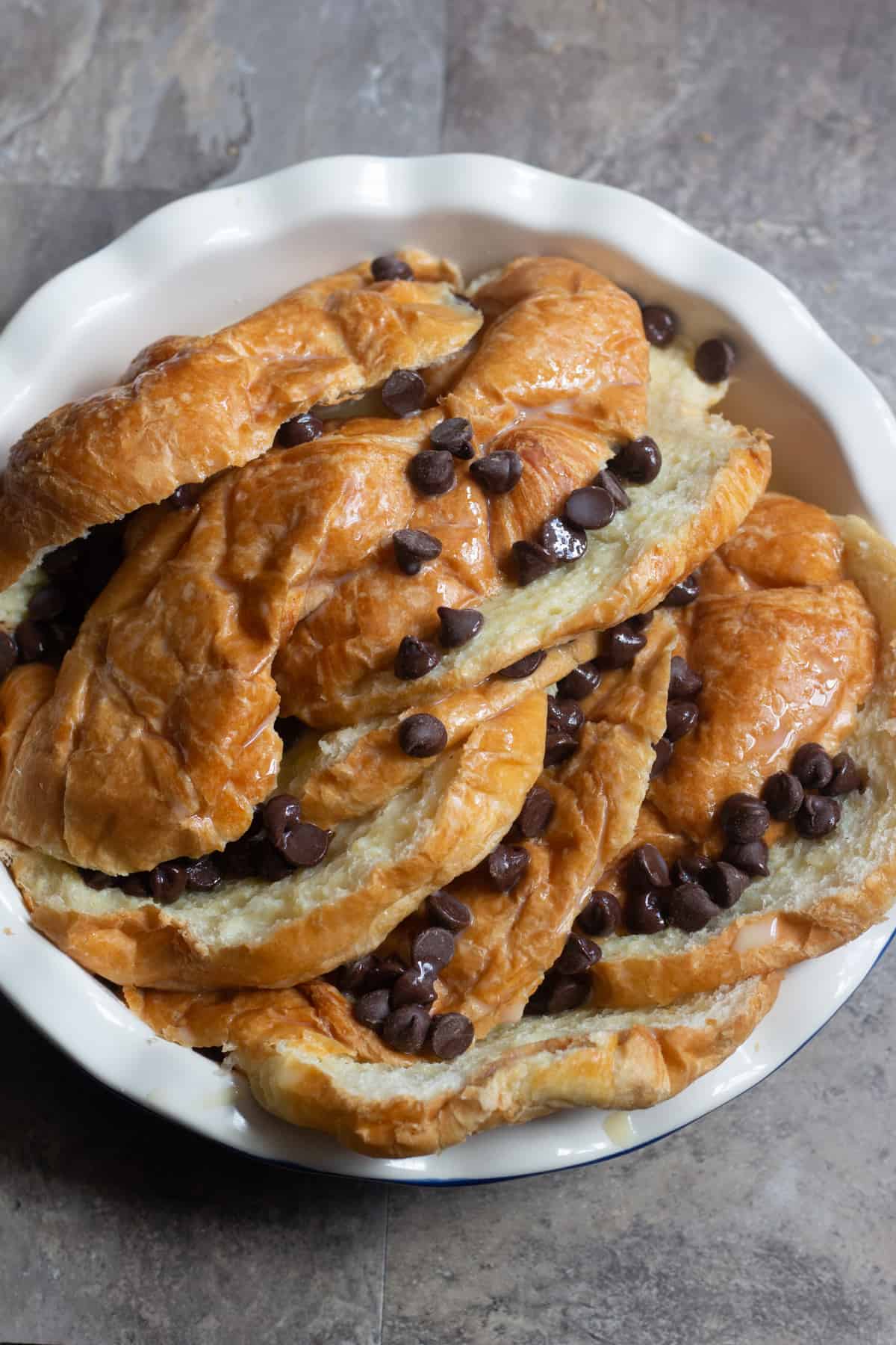 Top chocolate chip croissant bread pudding with sunbutter drizzle