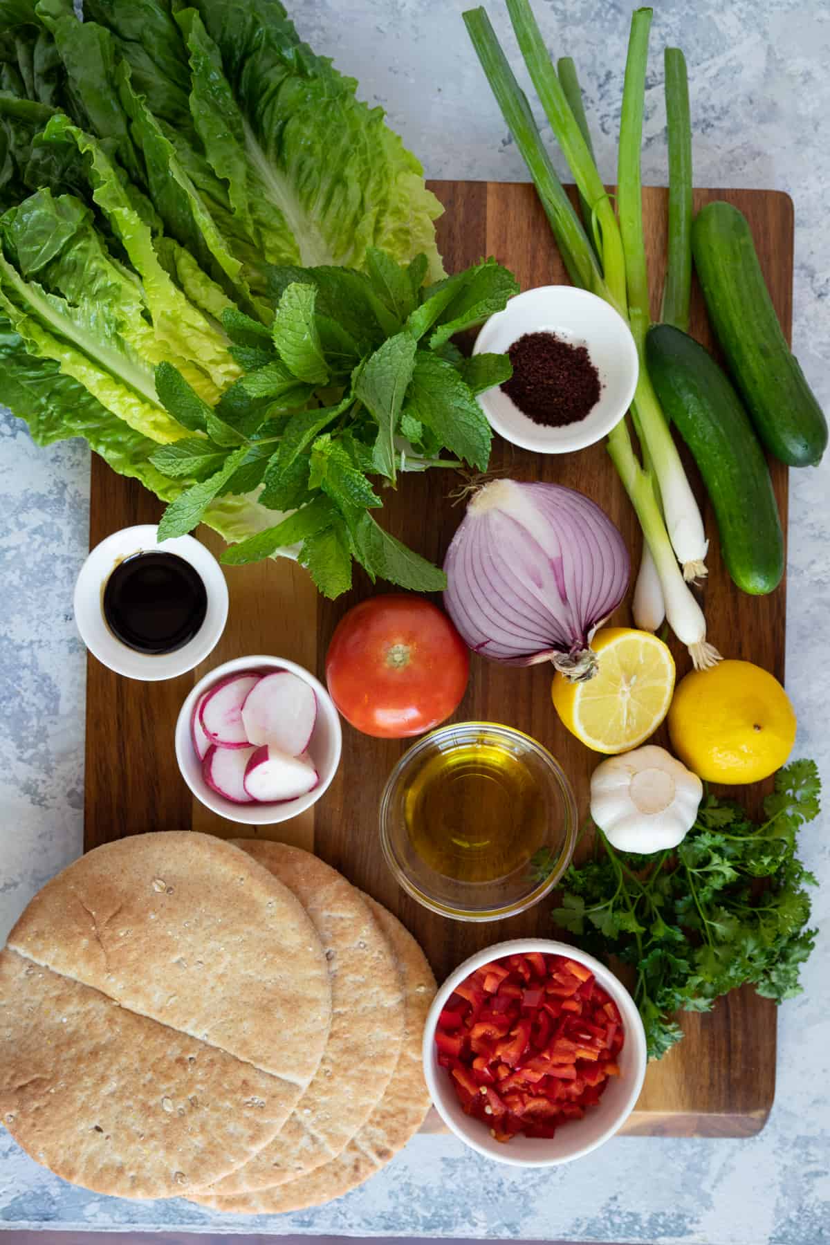 Lebanese salad ingredients are lettuce, radishes, tomatoes, lime, onion, sumac and parsley.