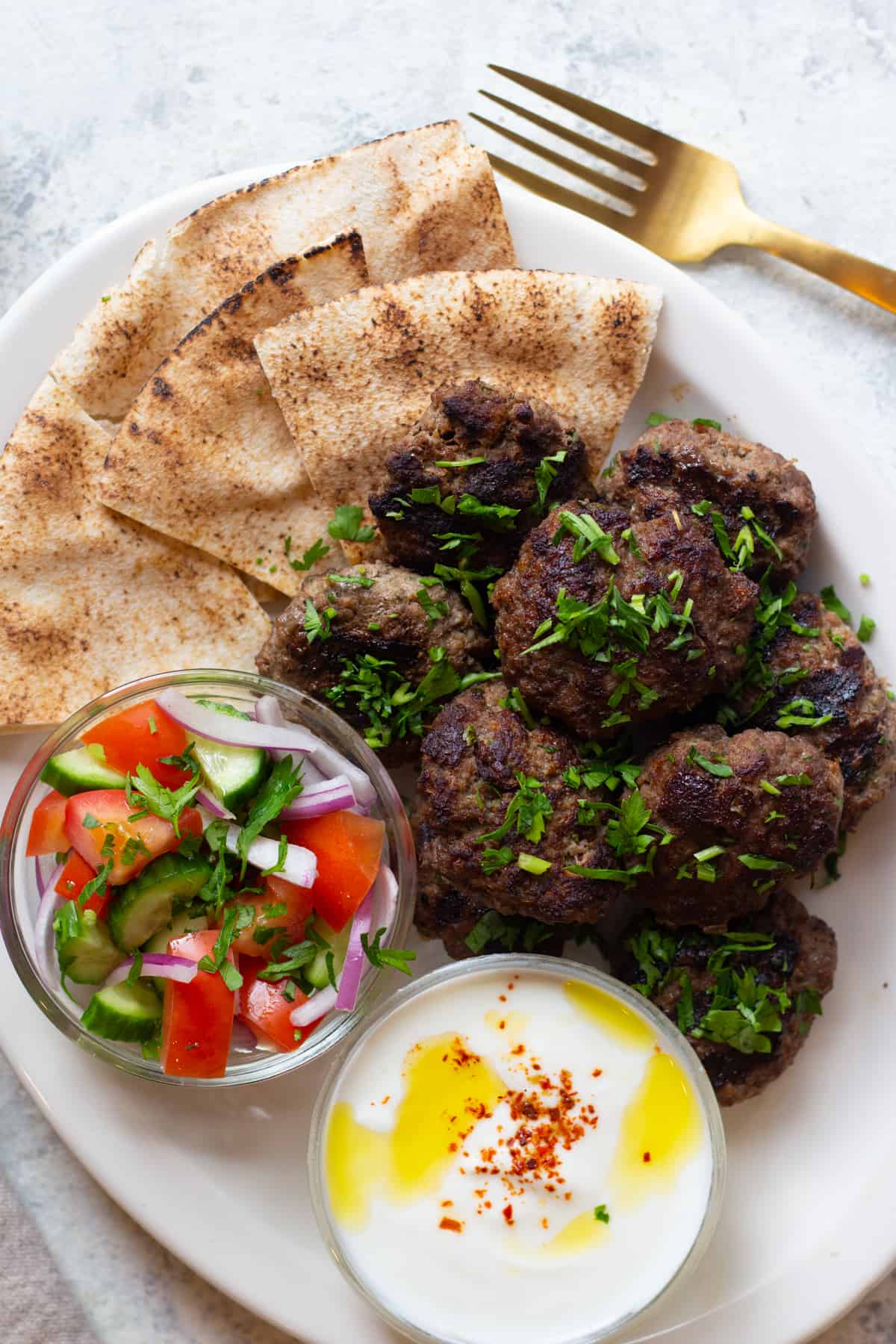 Kofta kebab with salad and yogurt. 