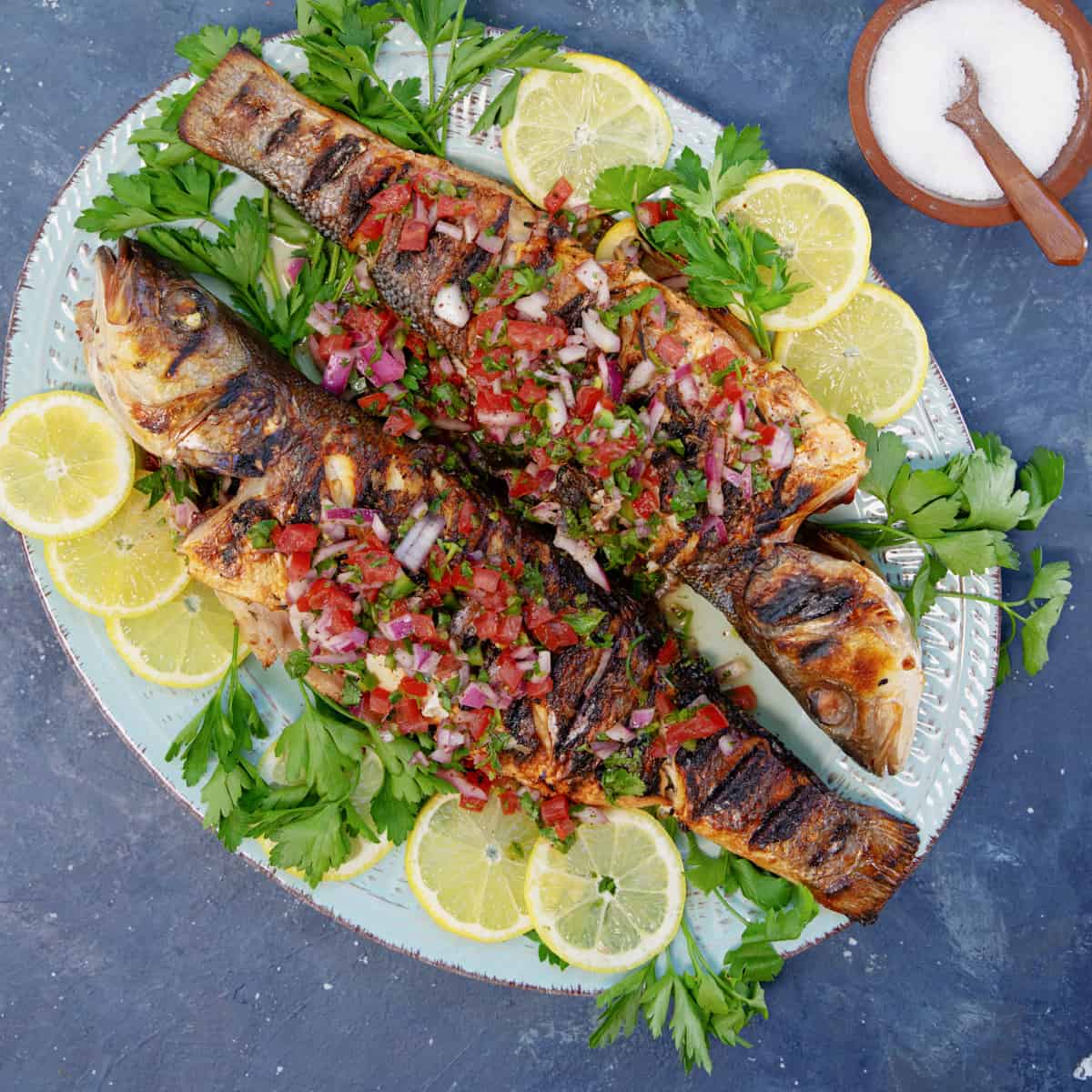 This grilled branzino recipe with a Mediterranean twist is a must-try! The fish is marinated with a herb and lemon mixture, then grilled to perfection and topped with a bright tomato herb relish. Trust me, there's a feast of flavors in every bite.
