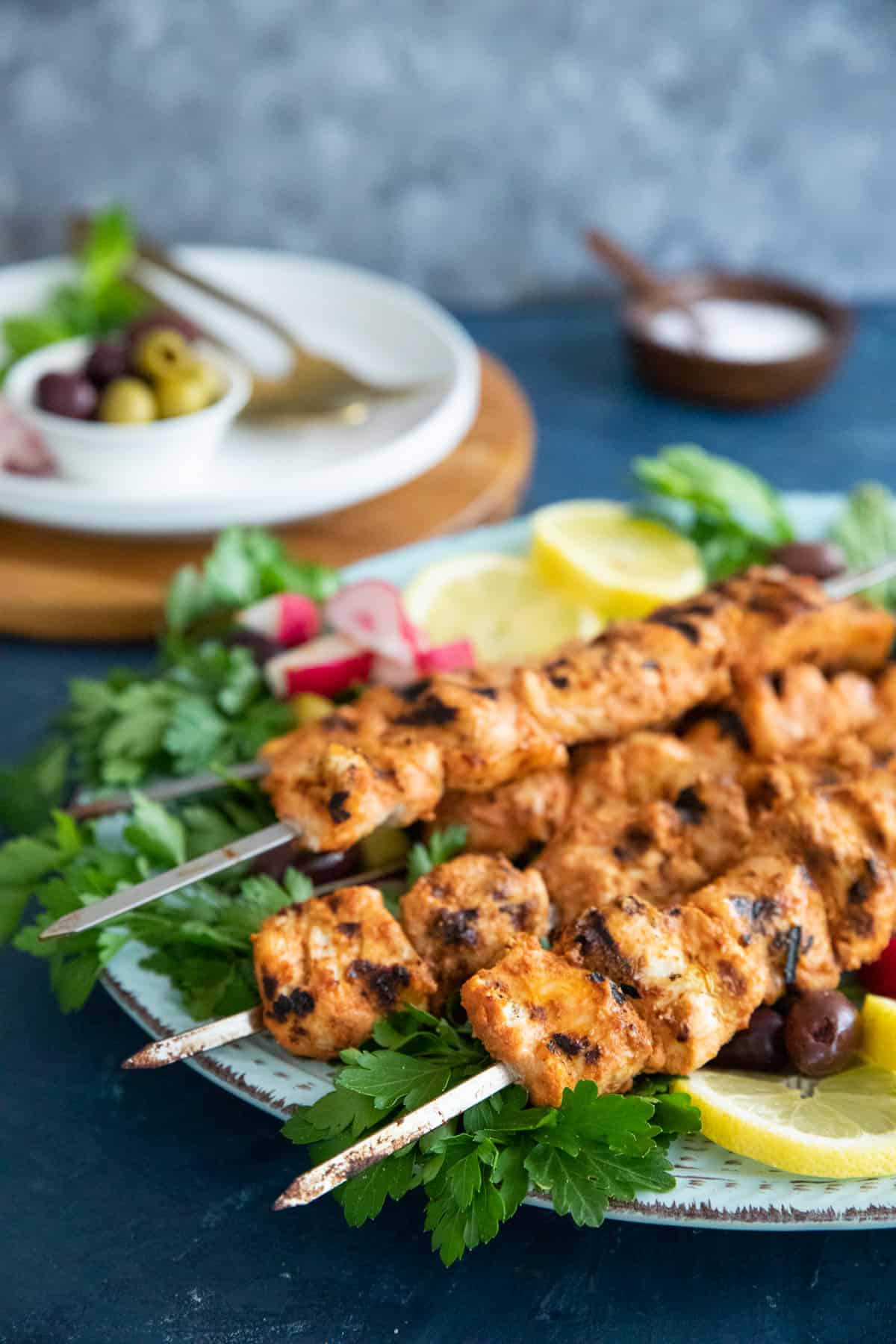grilled chicken skewers with parslet on a platter. 