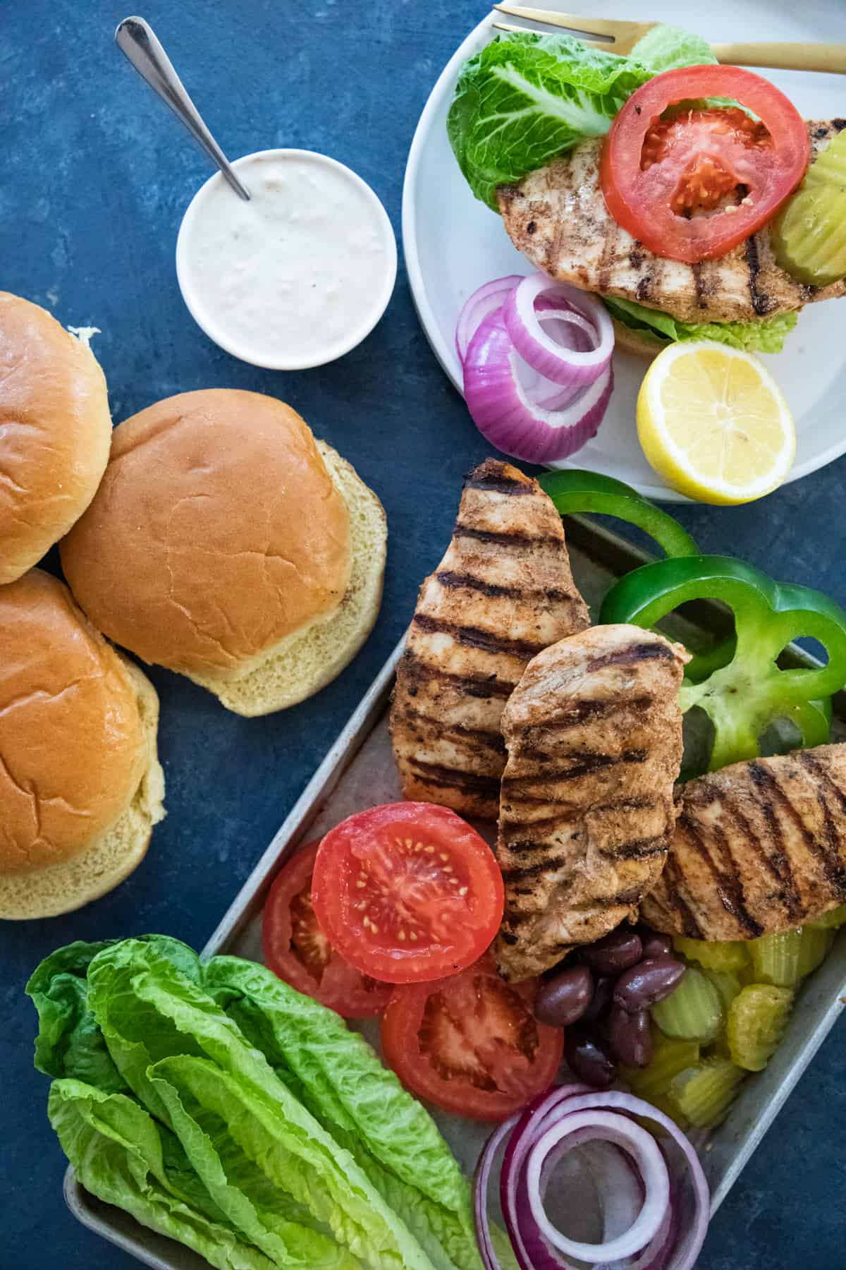 juicy chicken breast with onion, lettuce and tomatoes and pickles with buns.