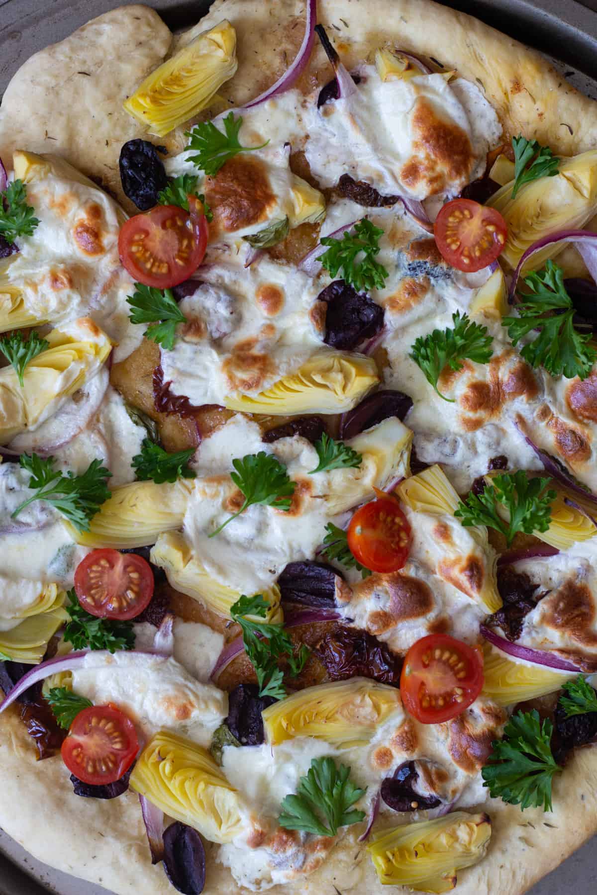 Mediterranean flat bread topped with artichoke hearts, tomatoes, olives and mozzarella cheese
