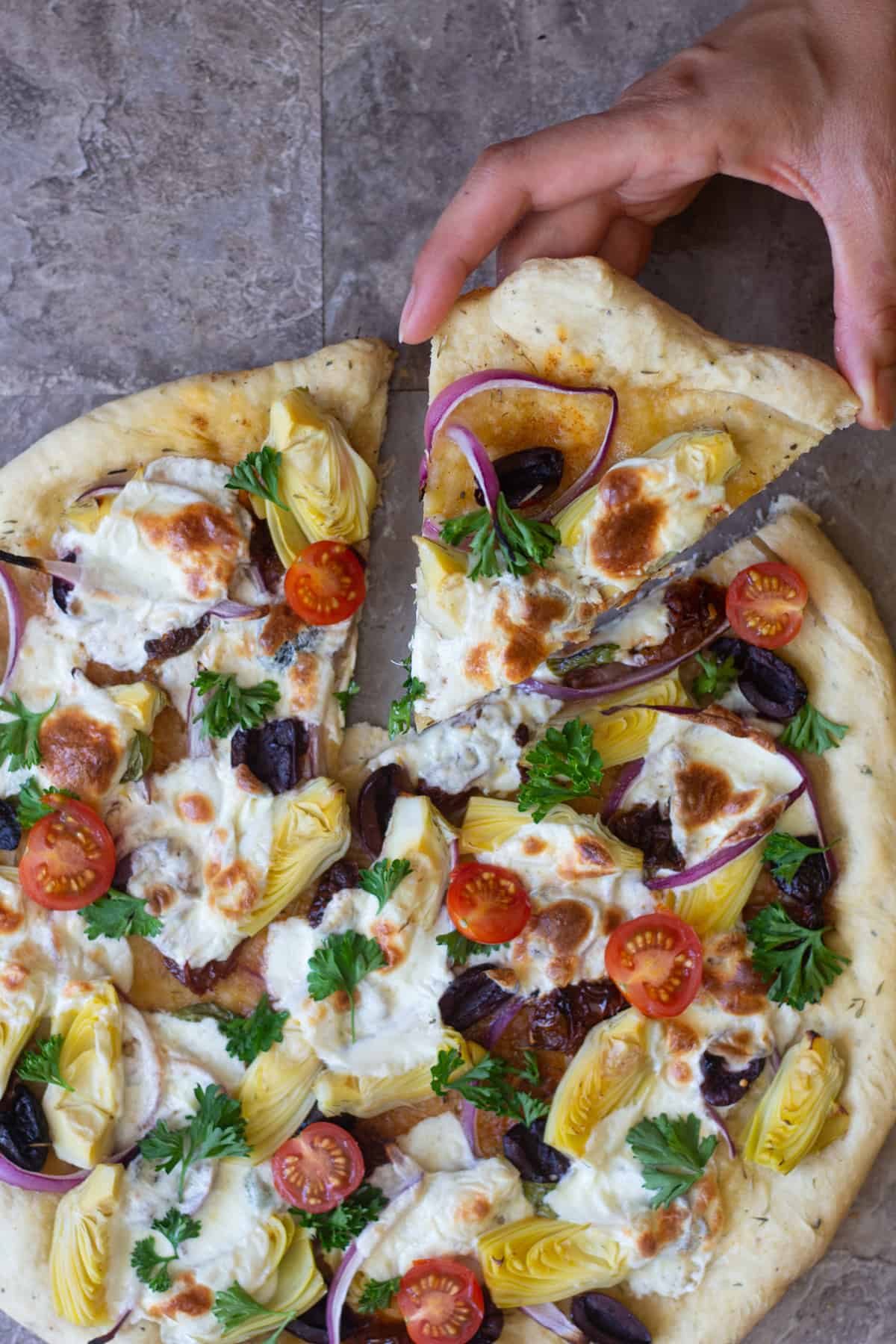 A slice of this Mediterranean pizza with red onion is perfect for dinner. 