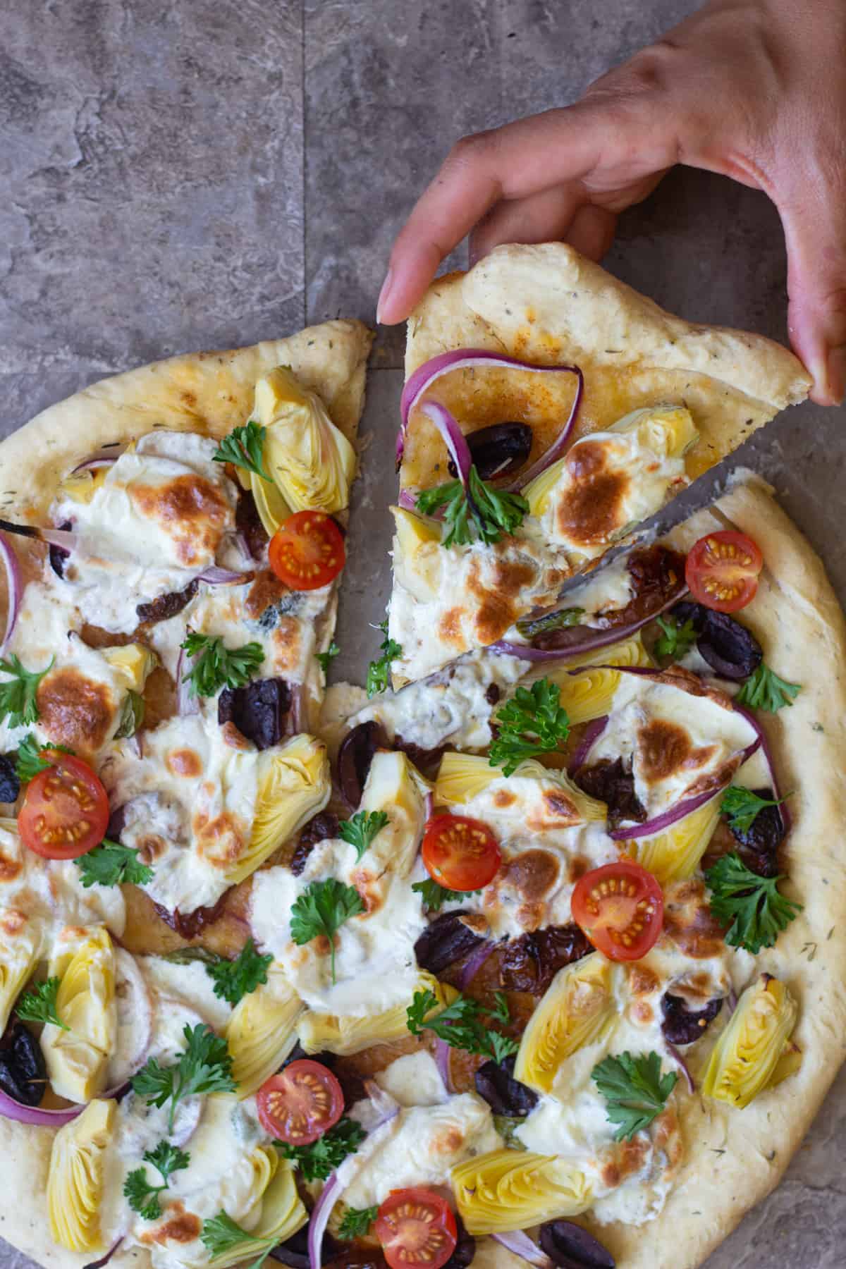 A slice of this Mediterranean pizza with red onion is perfect for dinner.