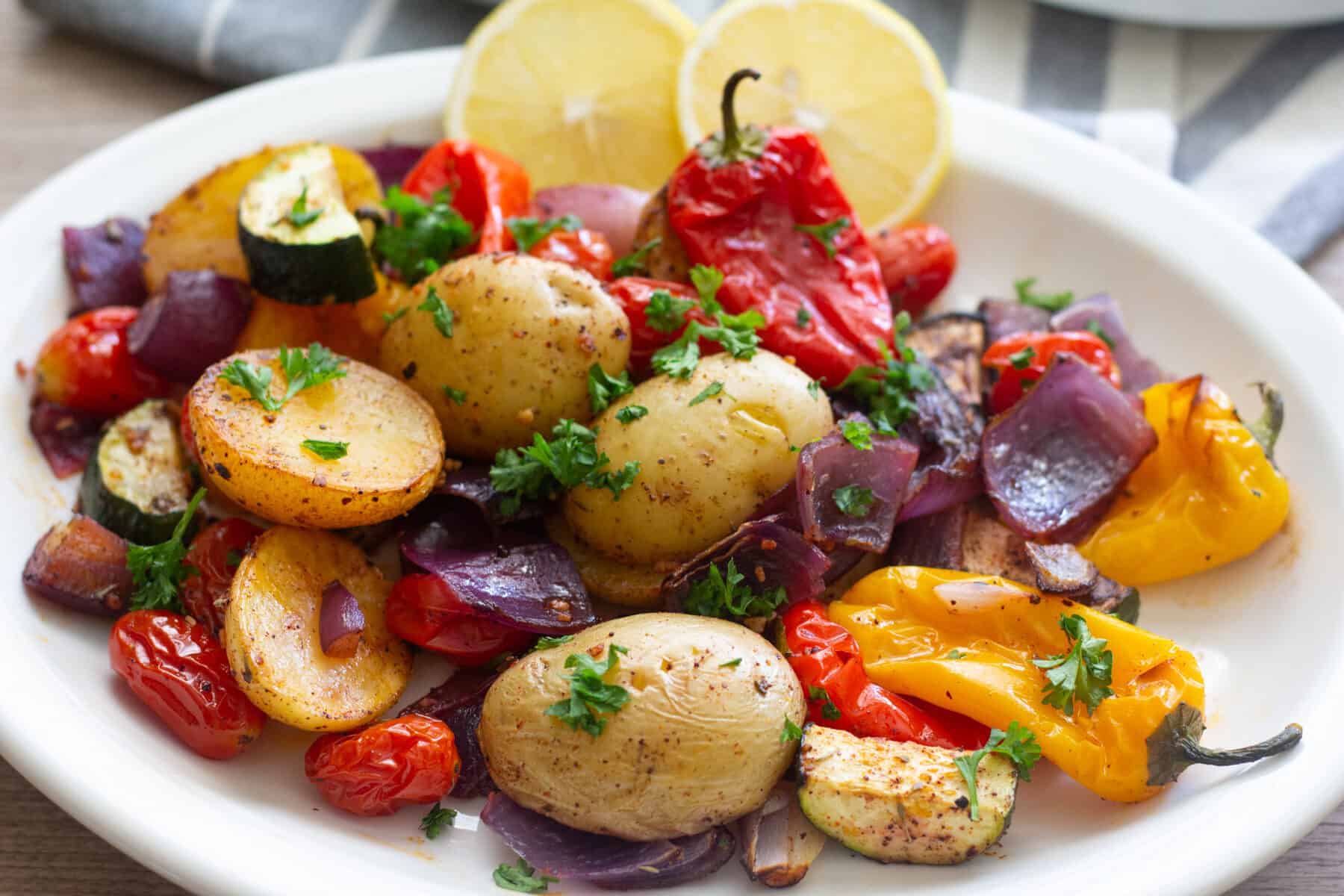 oven roasted vegetables made with potatoes onions, tomatoes and peppers.