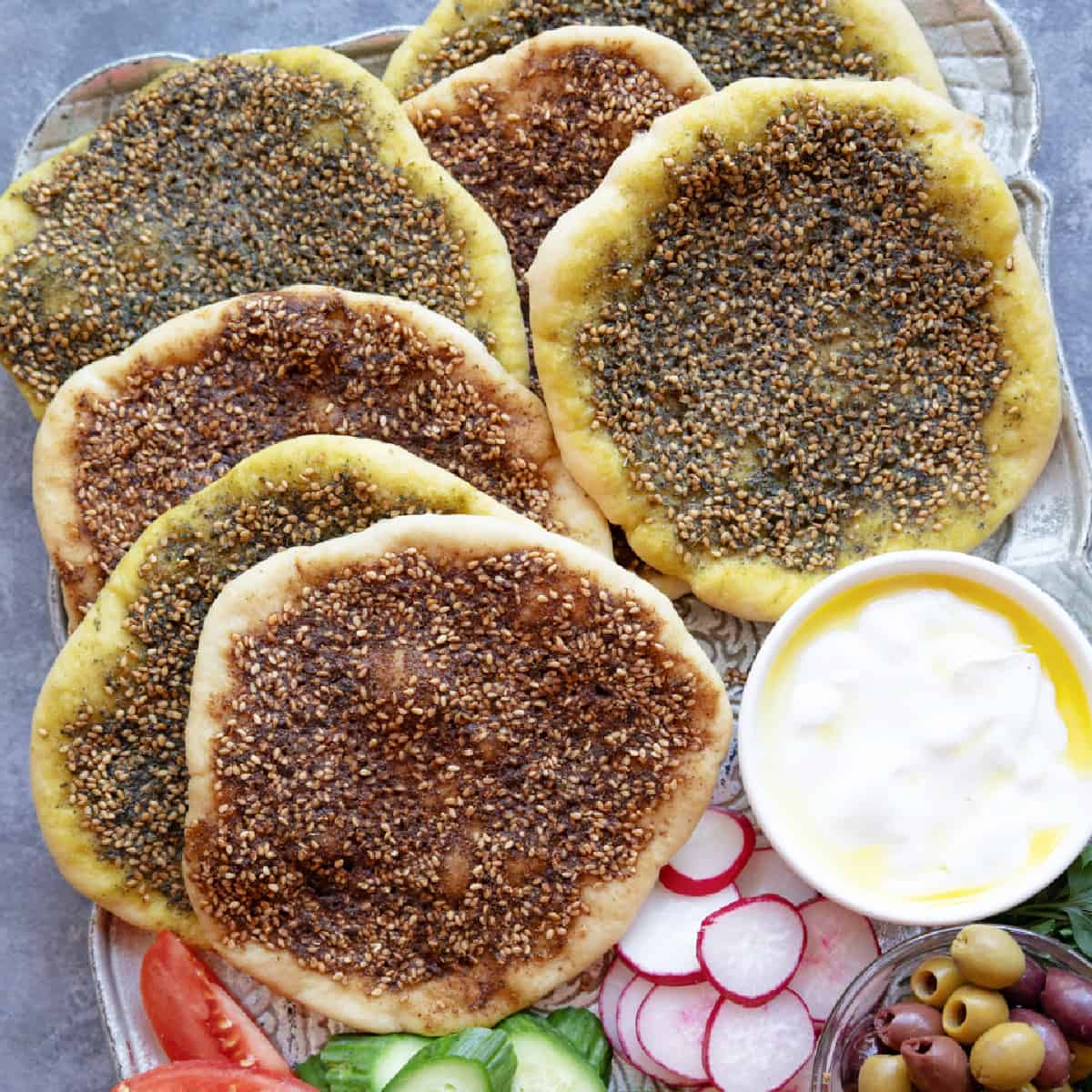 Manakish zaatar is a delicious Middle Eastern flatbread topped with zaatar. Learn how to make this delicious zaatar bread from scratch with just a few ingredients. 
