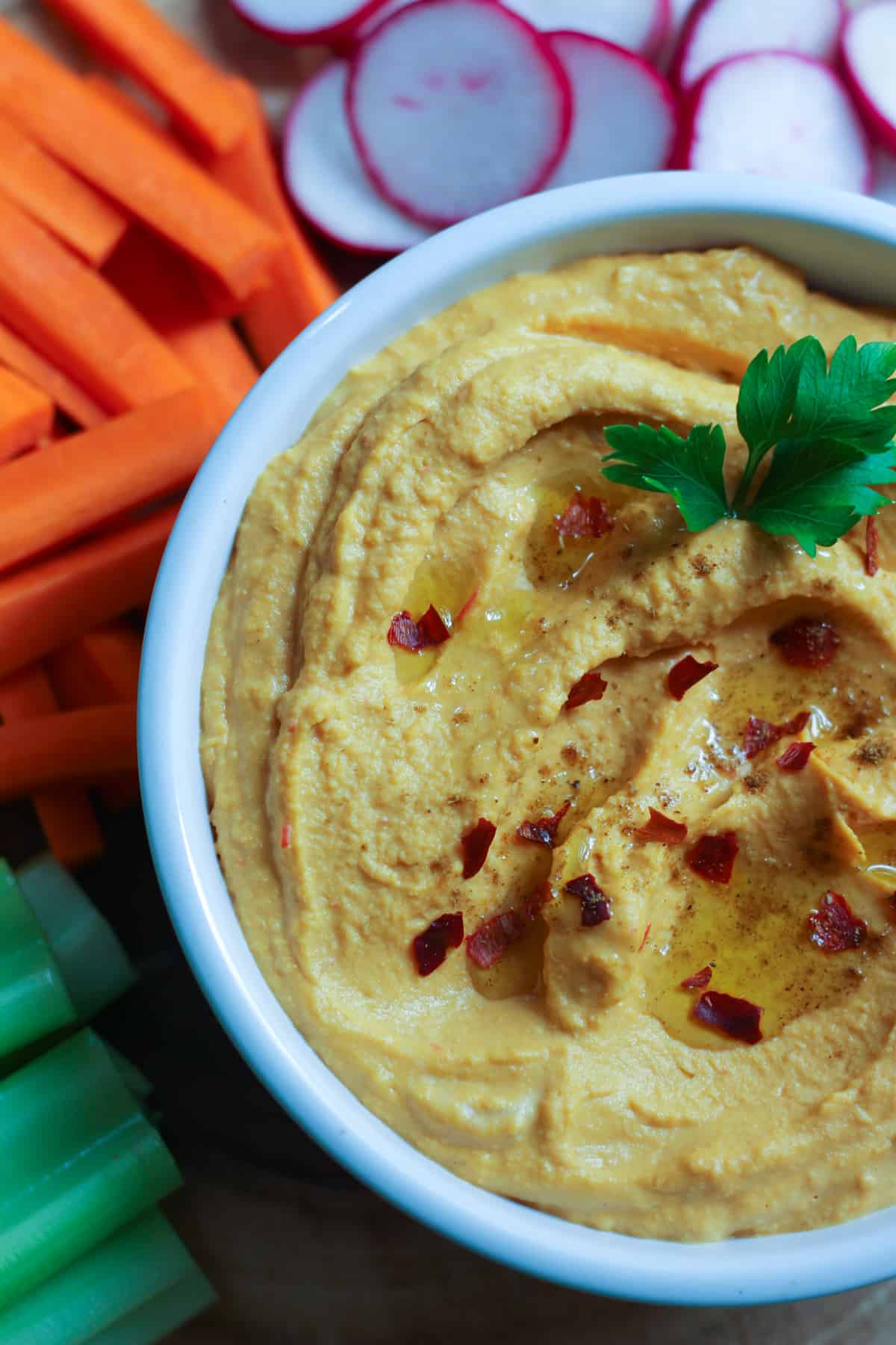 spicy hummus recipe is easy to follow and is topped with parsley, olive oil and pepper flakes. 