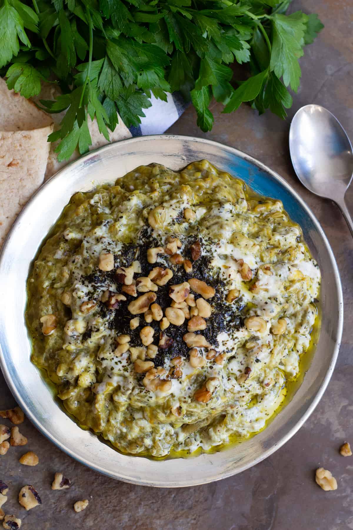 The toppings for this Persian eggplant dip are kashk, sauteed mint and walnuts.