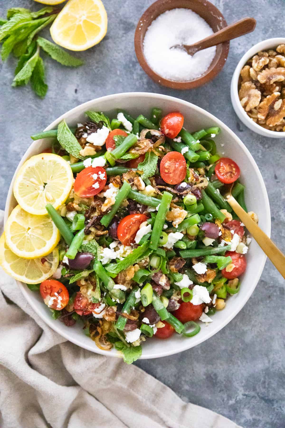 overhead shot of green bean salad with tomatoes and walnuts. 