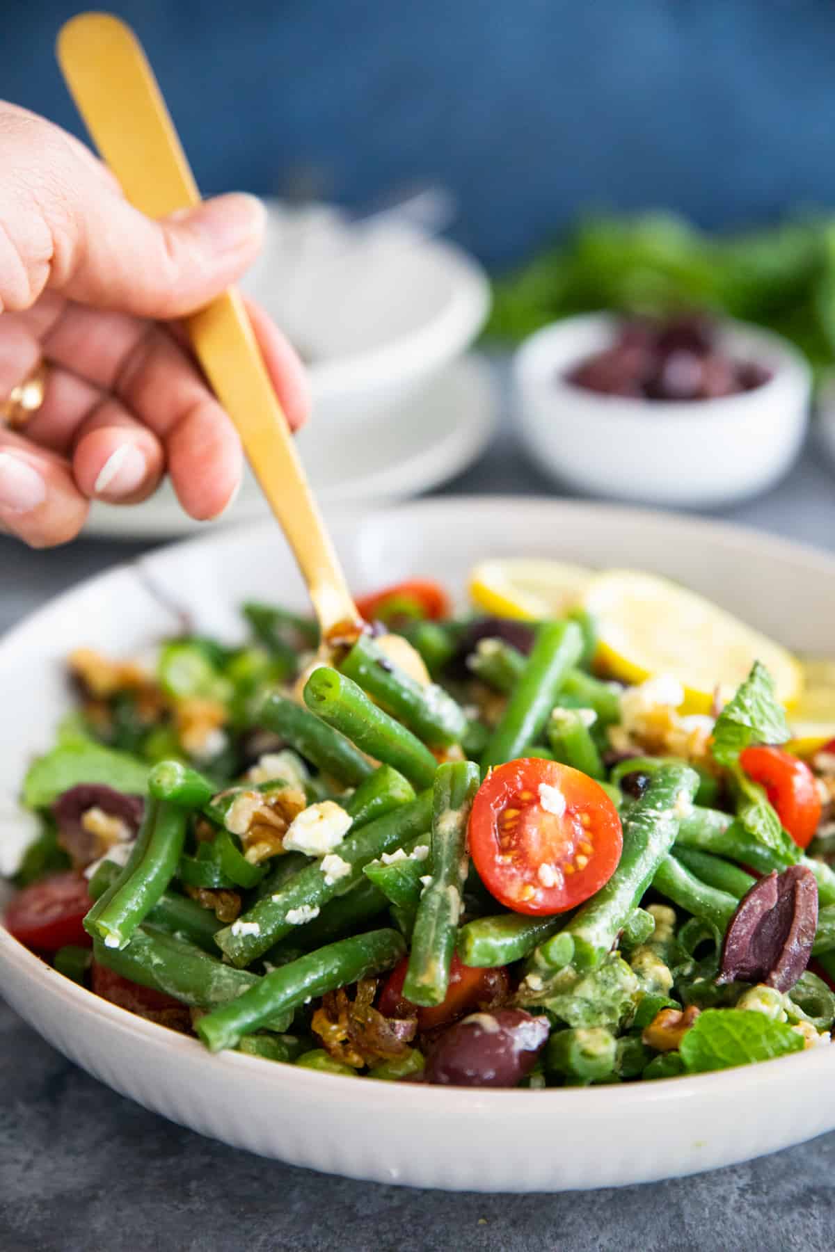 close up shot of Mediterranean green bean salad with a gold fork. 