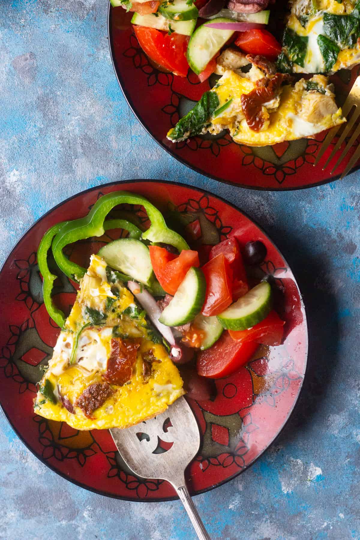 A slice of Mediterranean spinach omelette on a red plate.