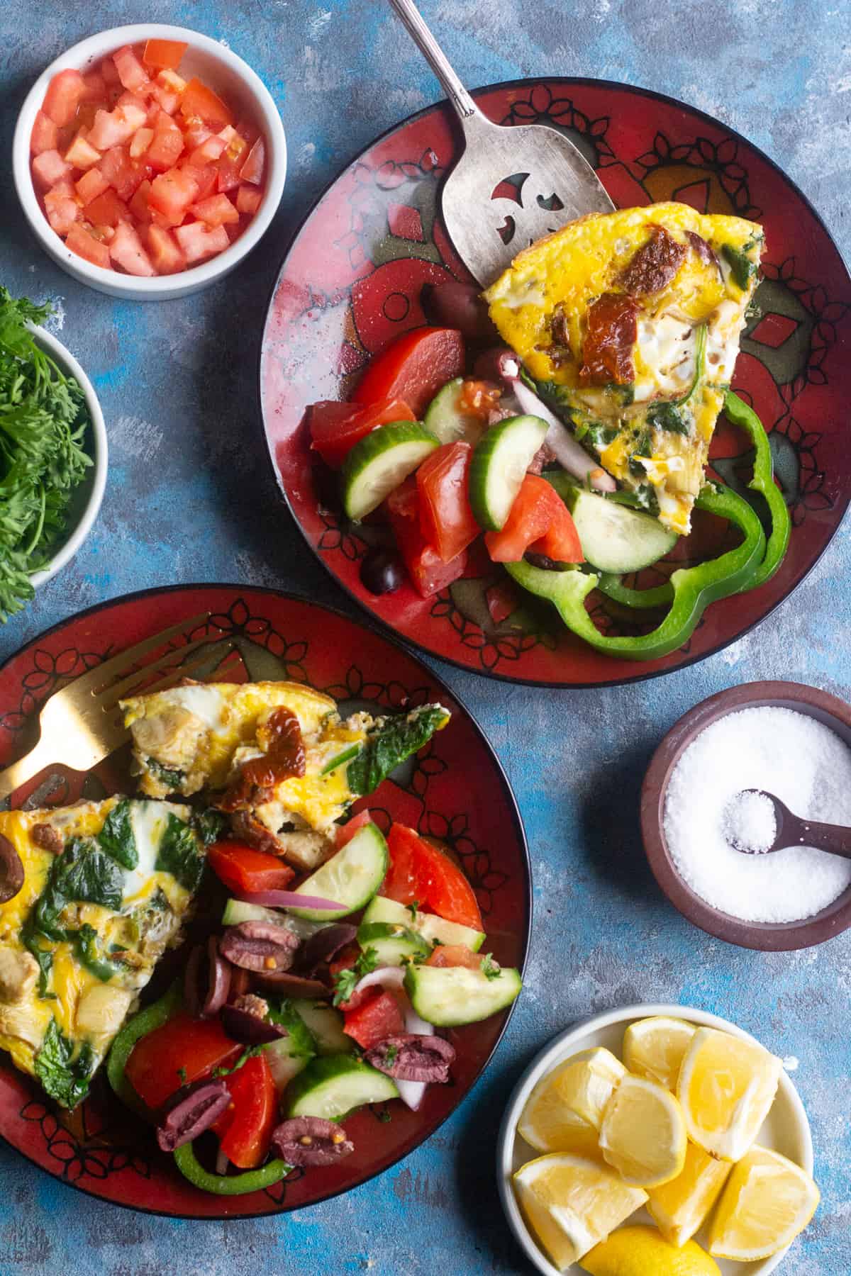 Overhead shot of spinach omelette on plates with salad. 