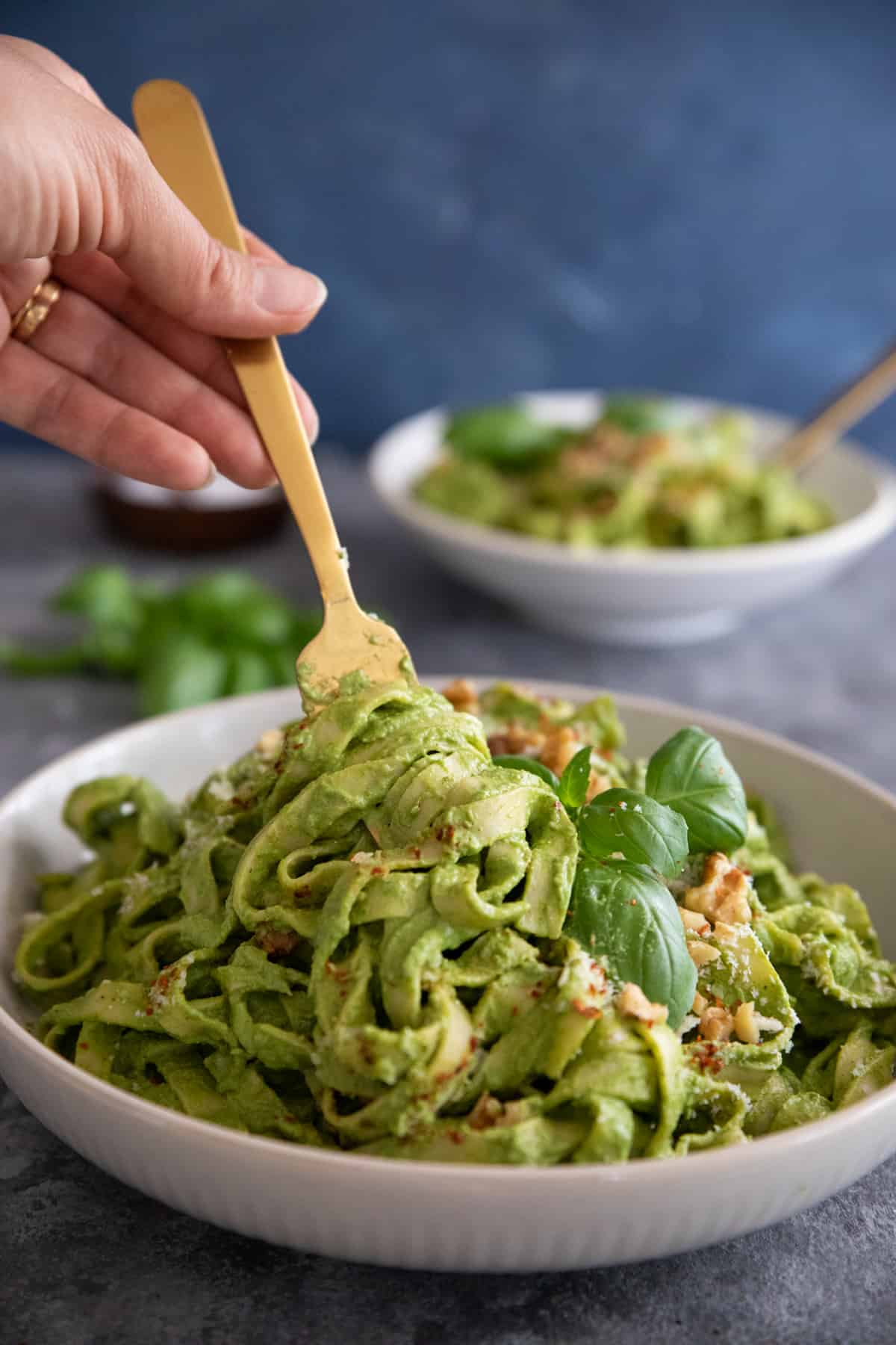 Gold fork serving creamy spinach pasta.