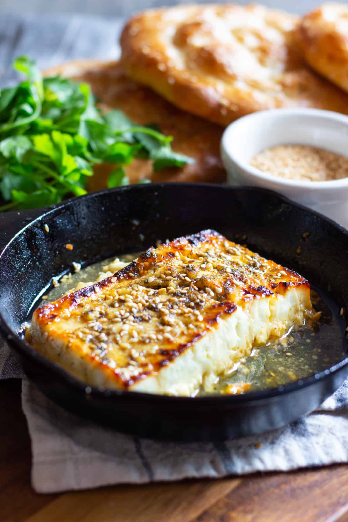 Baked feta in a cast iron skillet topped with honey and zaatar. 