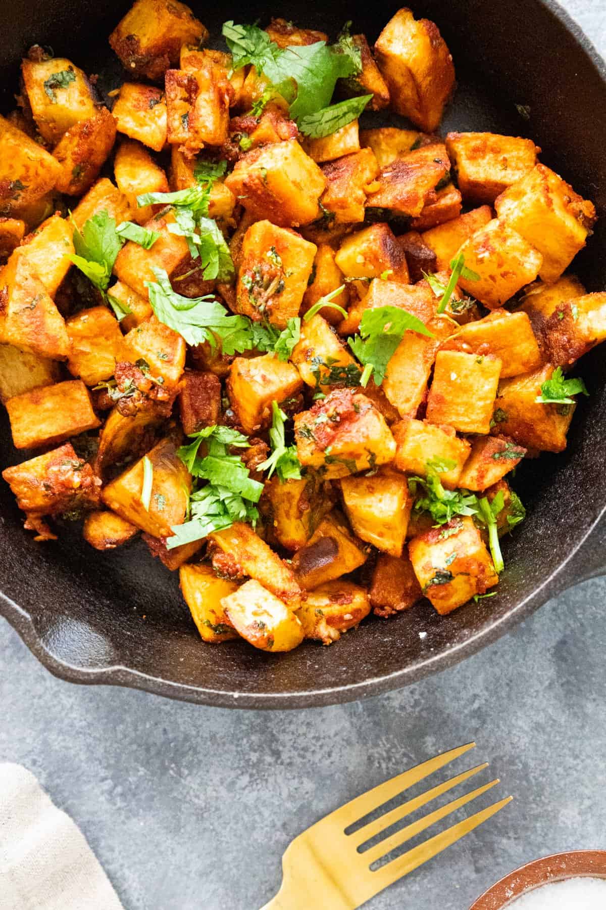 Middle Eastern spicy potatoes with garlic and cilantro in a cast iron skillet. 