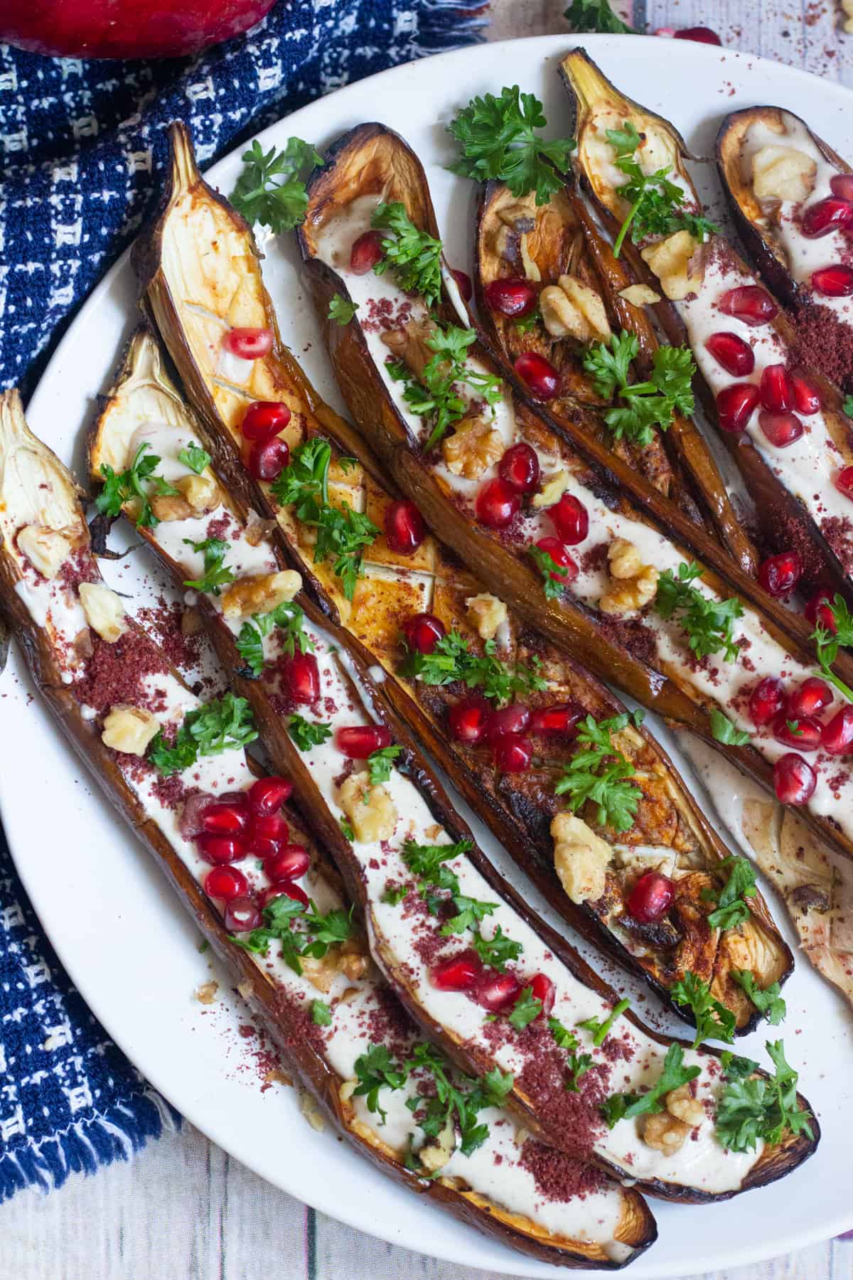 This is a great Middle Eastern eggplant recipe to always keep on hand. Perfectly roasted eggplant is served with a stunning tahini yogurt sauce and pomegranate arils. It's perfect as a side dish or an impressive appetizer!