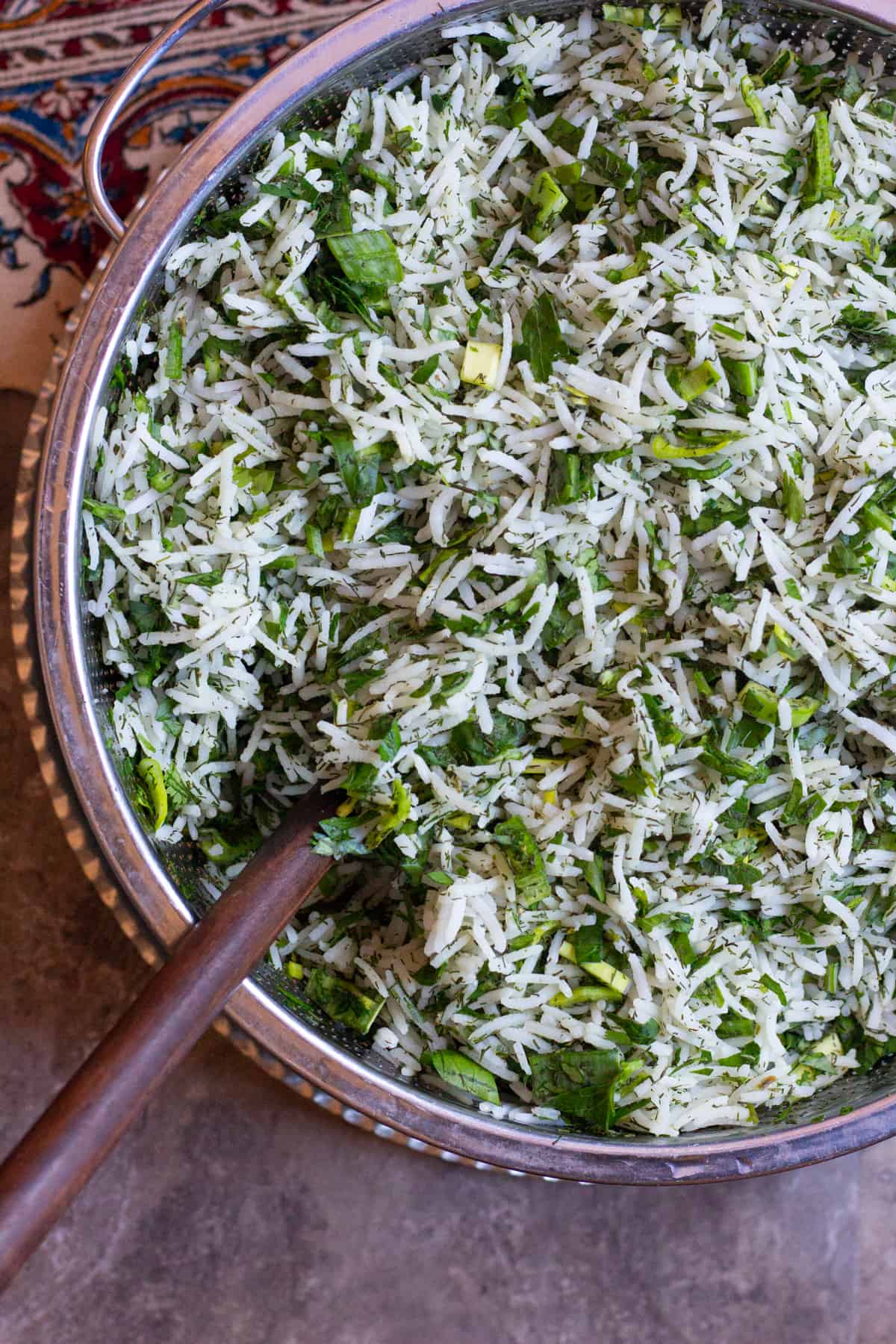 Drain the excess water and mix the herbs with par cooked rice in a colander. 