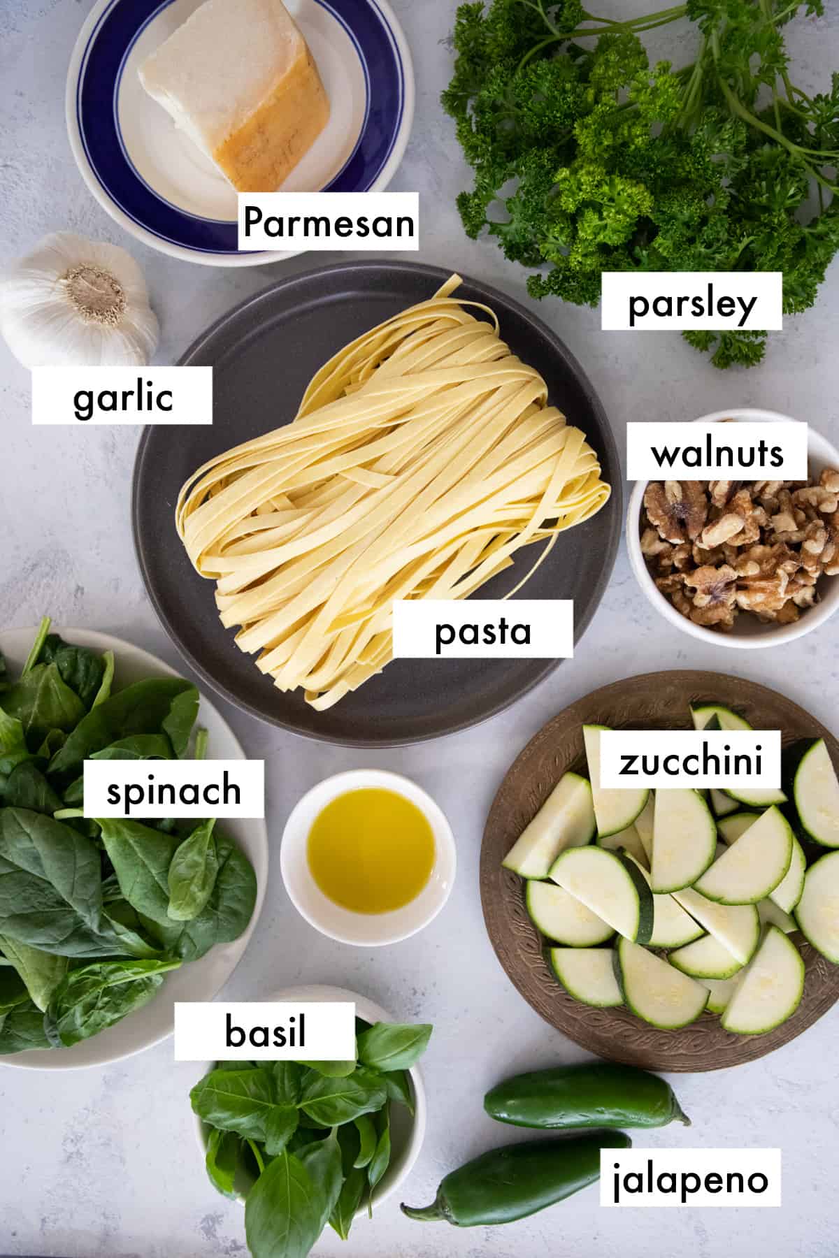 ingredients - you need pasta, spinach, zucchini, basil, garlic, walnuts, jalapeno, parsley, olive oil and parmesan.