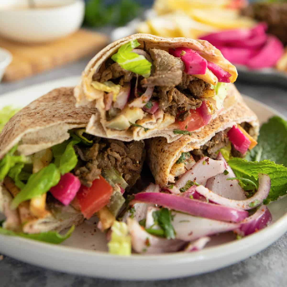 Beef shawarma is a classic Middle Eastern street food. Tender slices of beef are marinated in olive oil and warm shawarma spices and cooked to perfection, then wrapped in a pita bread with vegetables and fries. Learn how to make beef shawarma at home with my tips and tricks.
