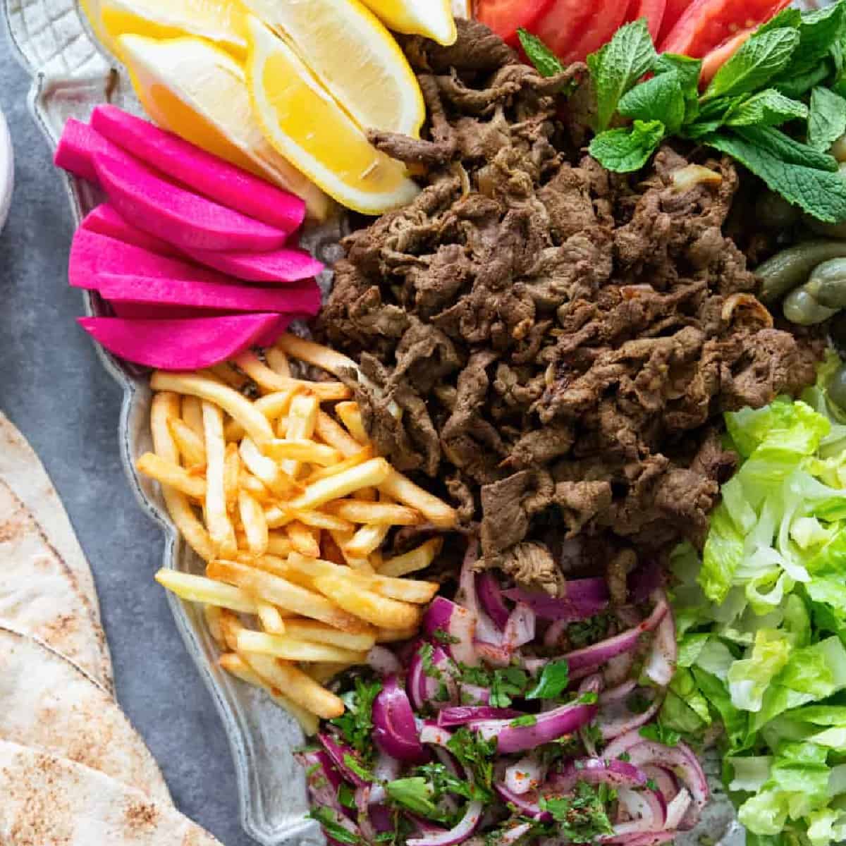 Beef shawarma is a classic Middle Eastern street food. Tender slices of beef are marinated in olive oil and warm shawarma spices and cooked to perfection, then wrapped in a pita bread with vegetables and fries. Learn how to make beef shawarma at home with my tips and tricks.
