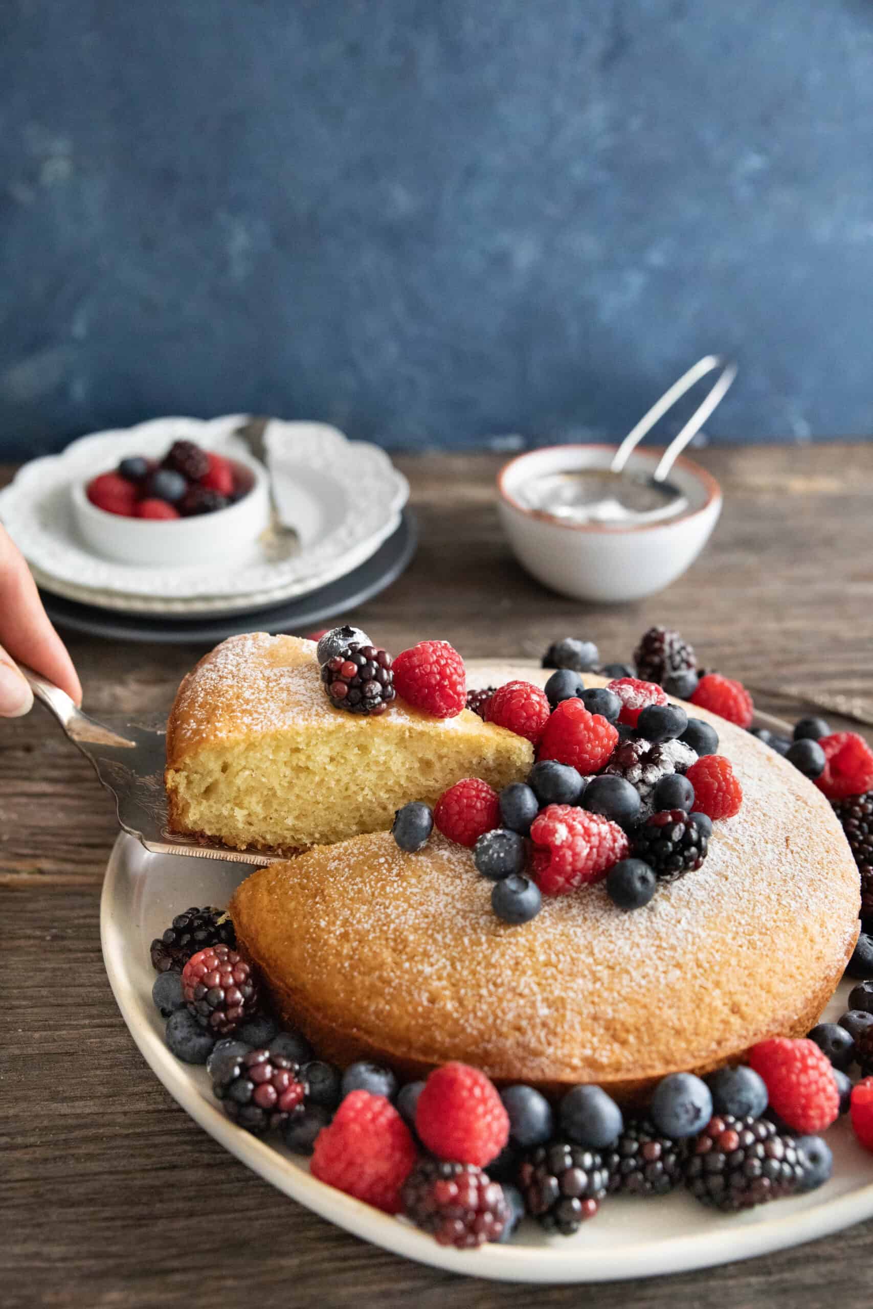 A slice of cake getting picked off the plate.