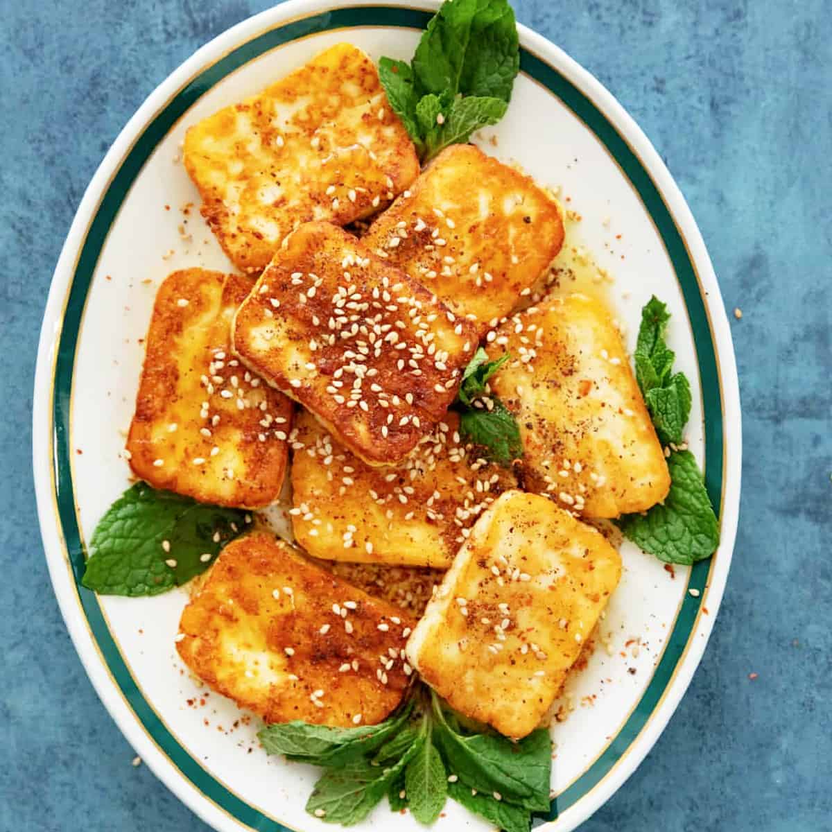 Fried halloumi with honey on a white plate.