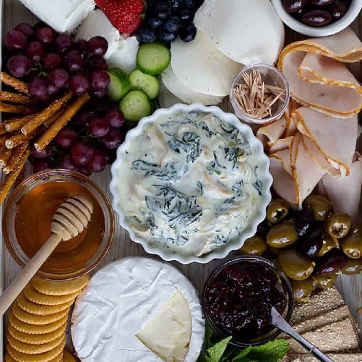 This cold spinach artichoke dip is a great addition to any summer charcuterie board. Make this bright and tasty cheese board for all your summer parties! 
